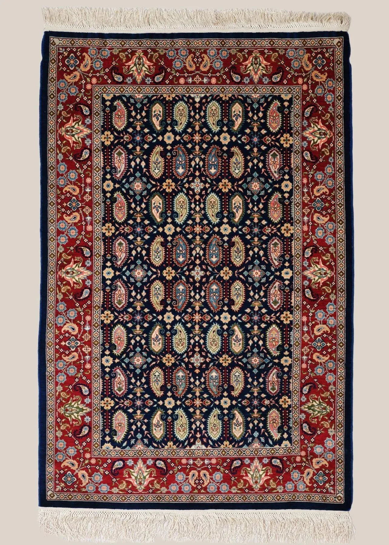 A traditional Persian-style area rug with a central navy blue field, intricate floral and paisley patterns, and a red border with matching floral motifs.