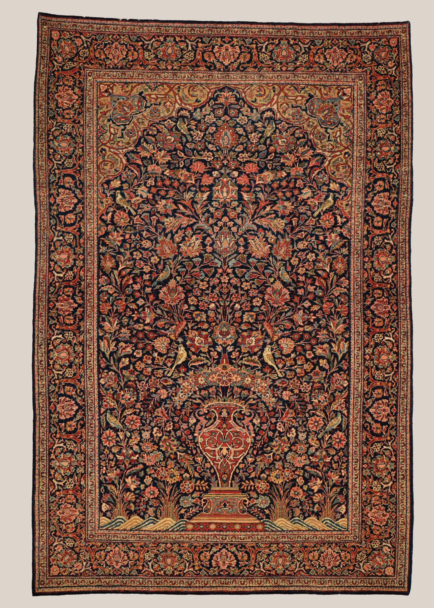 A traditional Persian rug with intricate floral patterns in dark blue, red, beige, and gold, featuring a central medallion and border design.