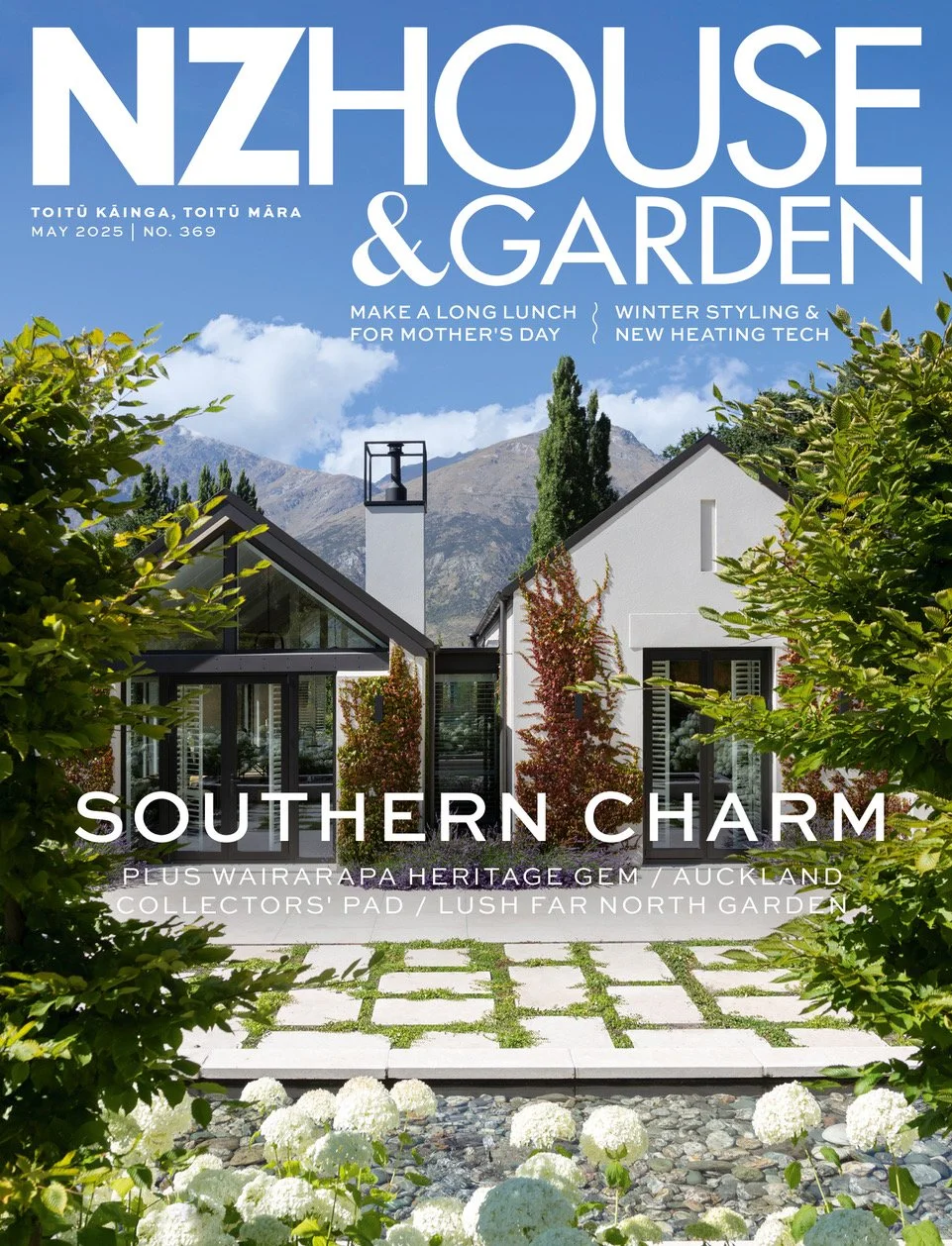 Cover of NZ House & Garden magazine, May 2025 issue, featuring a modern white house with large windows and a garden path surrounded by greenery and flowers, with mountains in the background.