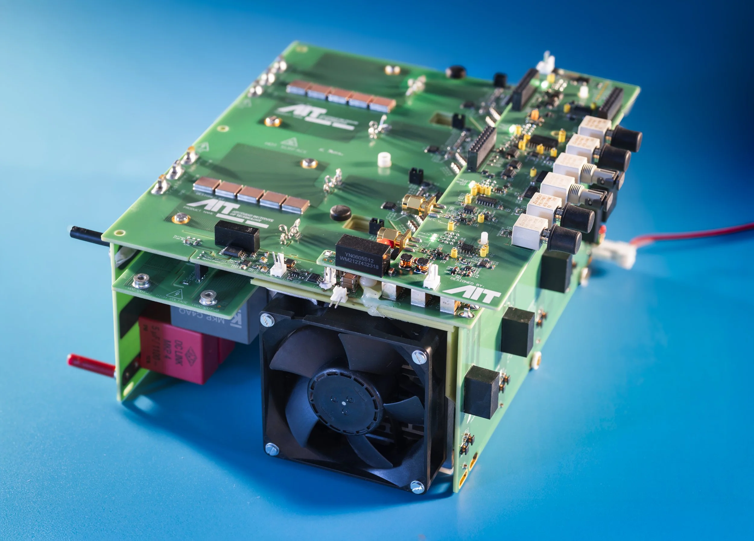 The image shows a green printed circuit board (PCB) with various electronic components such as resistors, capacitors, and microchips.