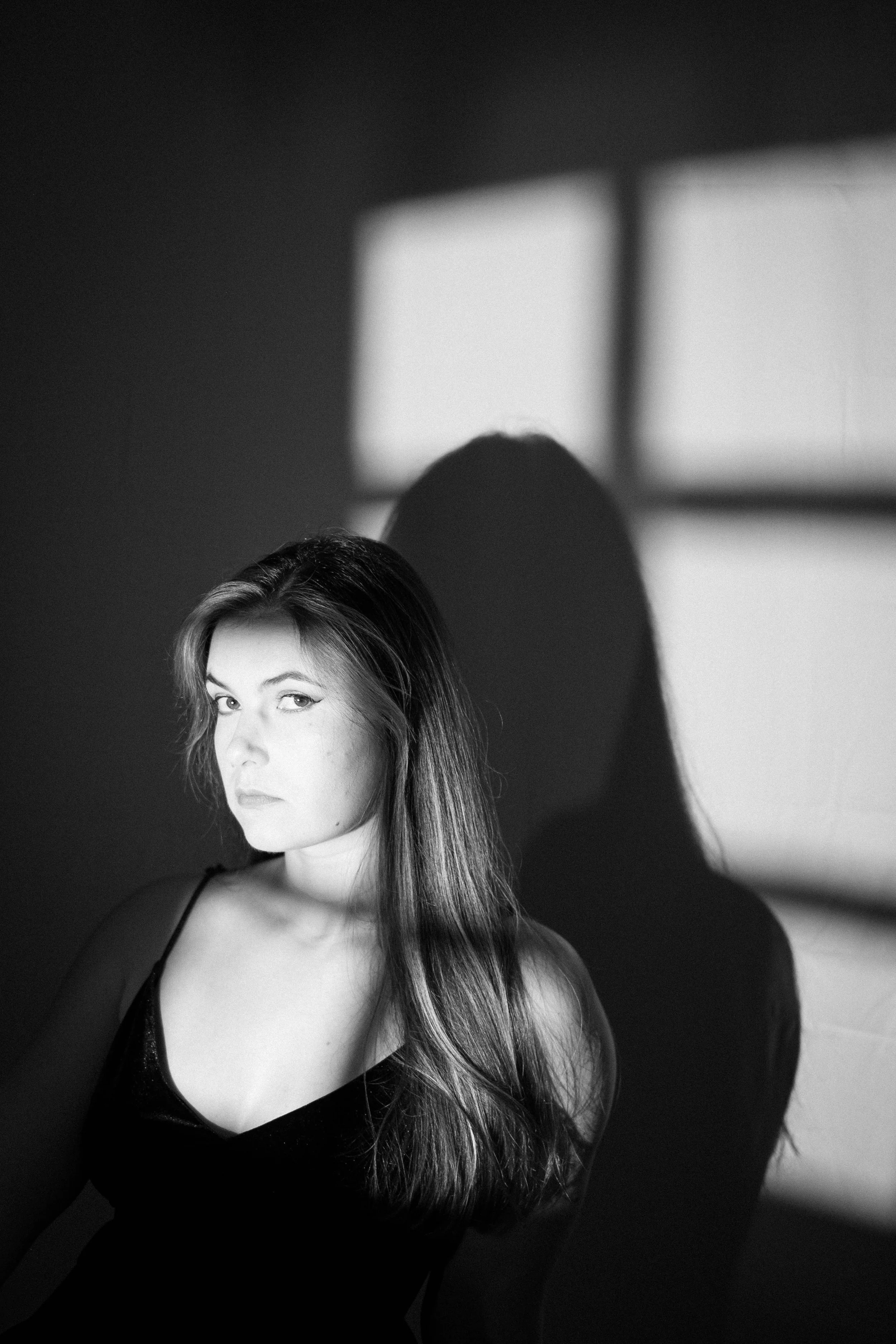 Femme allongée dans un champ de tall grass avec un chapeau noir