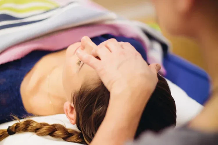 Access Bars session in Reading with Nadene, showing a practitioner gently holding the head to promote deep relaxation and wellbeing.
