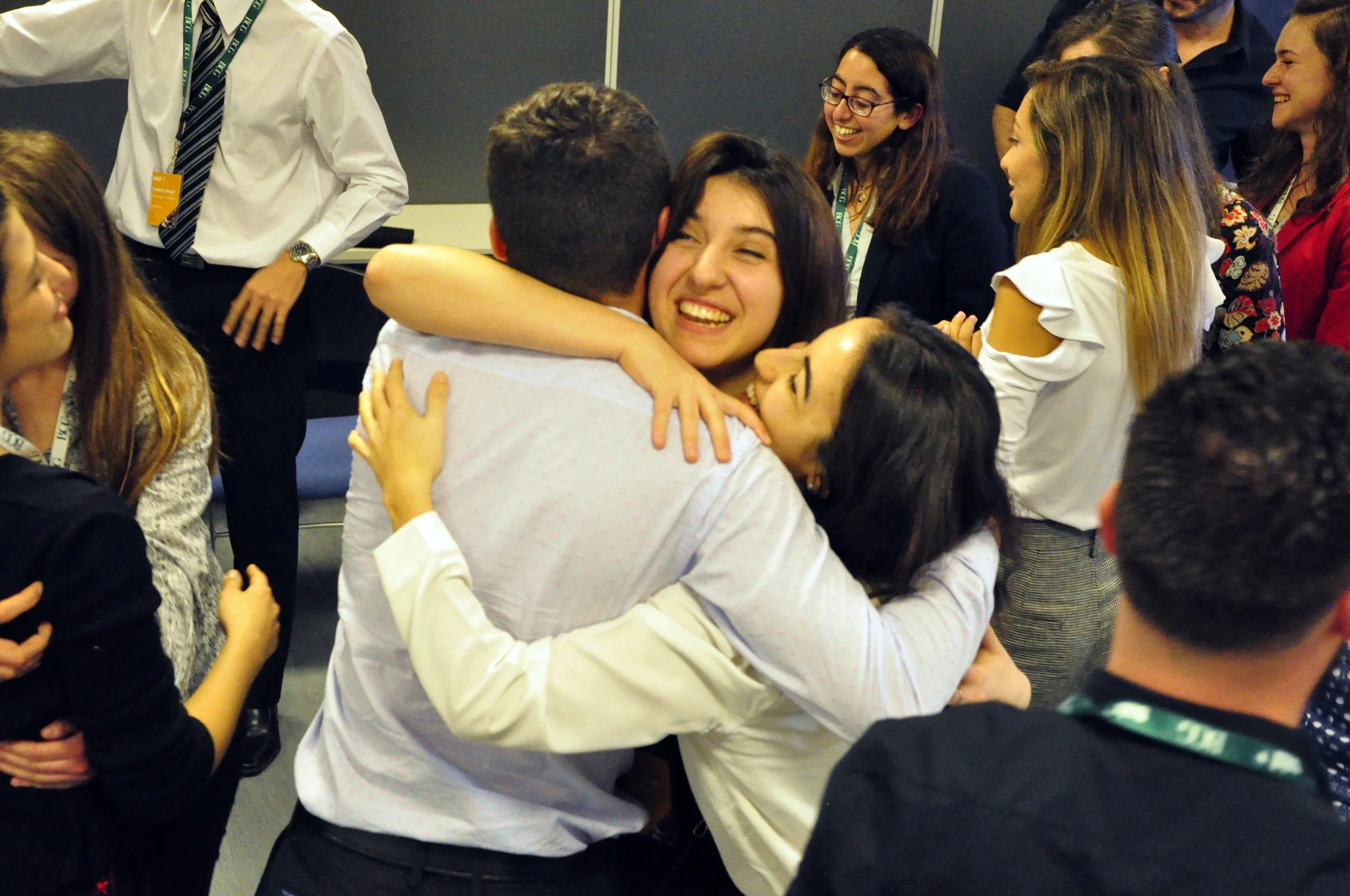 Grupo de personas celebrando y abrazándose en una reunión o evento.