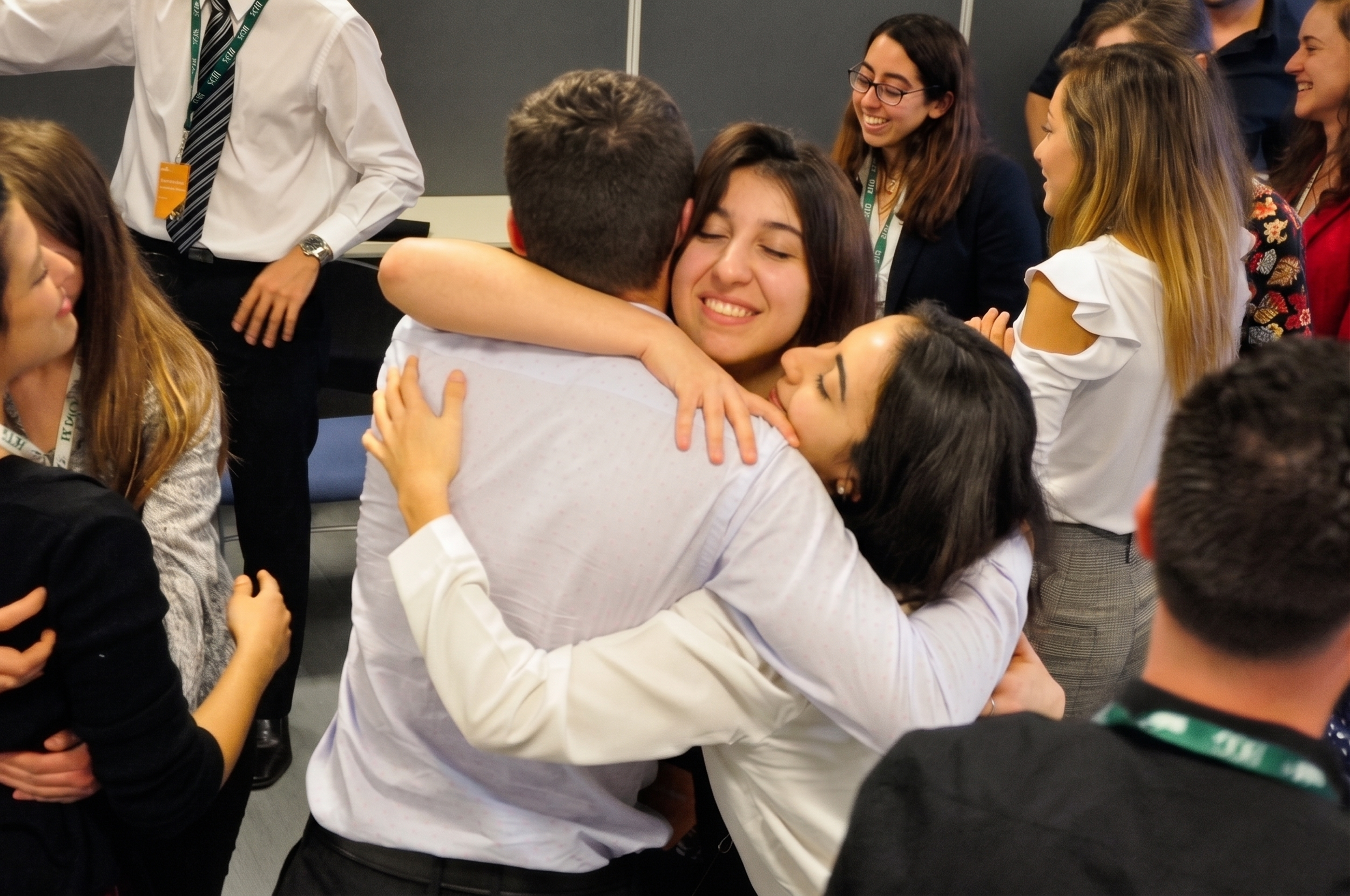 Grupo de personas en un evento de networking, abrazándose y sonriendo.