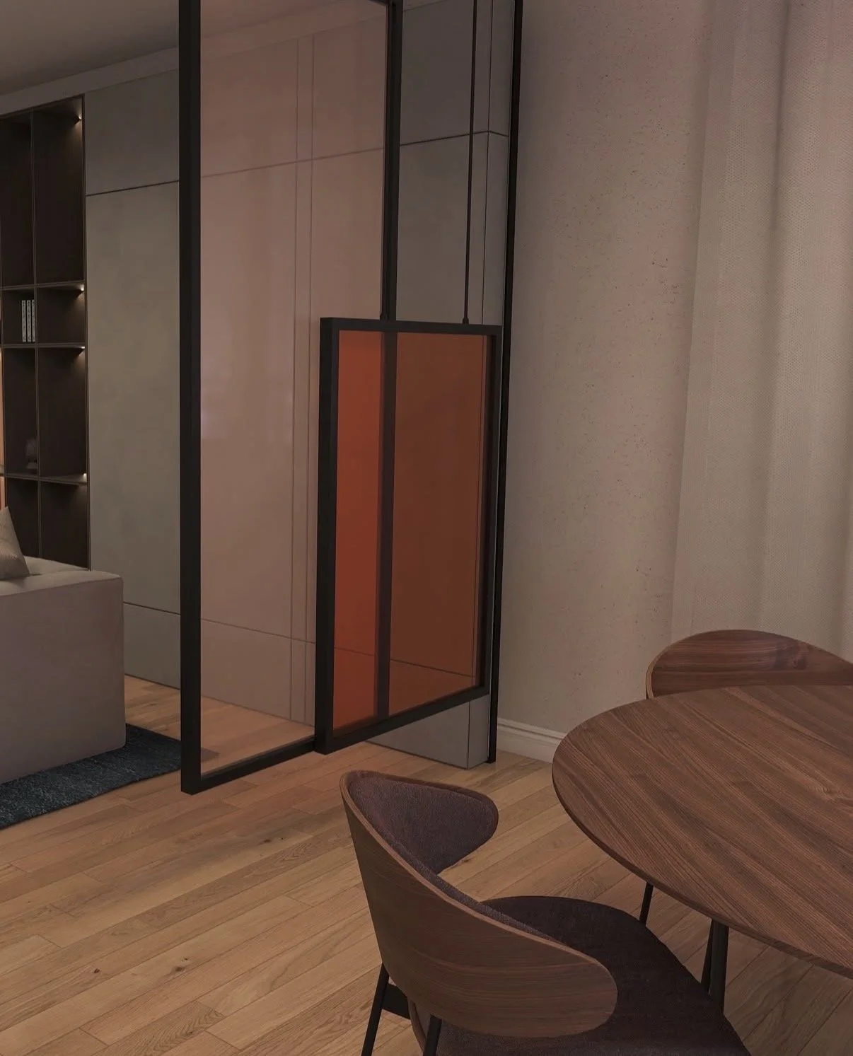 A modern interior space featuring a round wooden dining table with dark upholstered chairs, a folding black metal and wood room divider, a built-in wall bookshelf, and a beige sofa. The room has light wood flooring and neutral-colored walls.