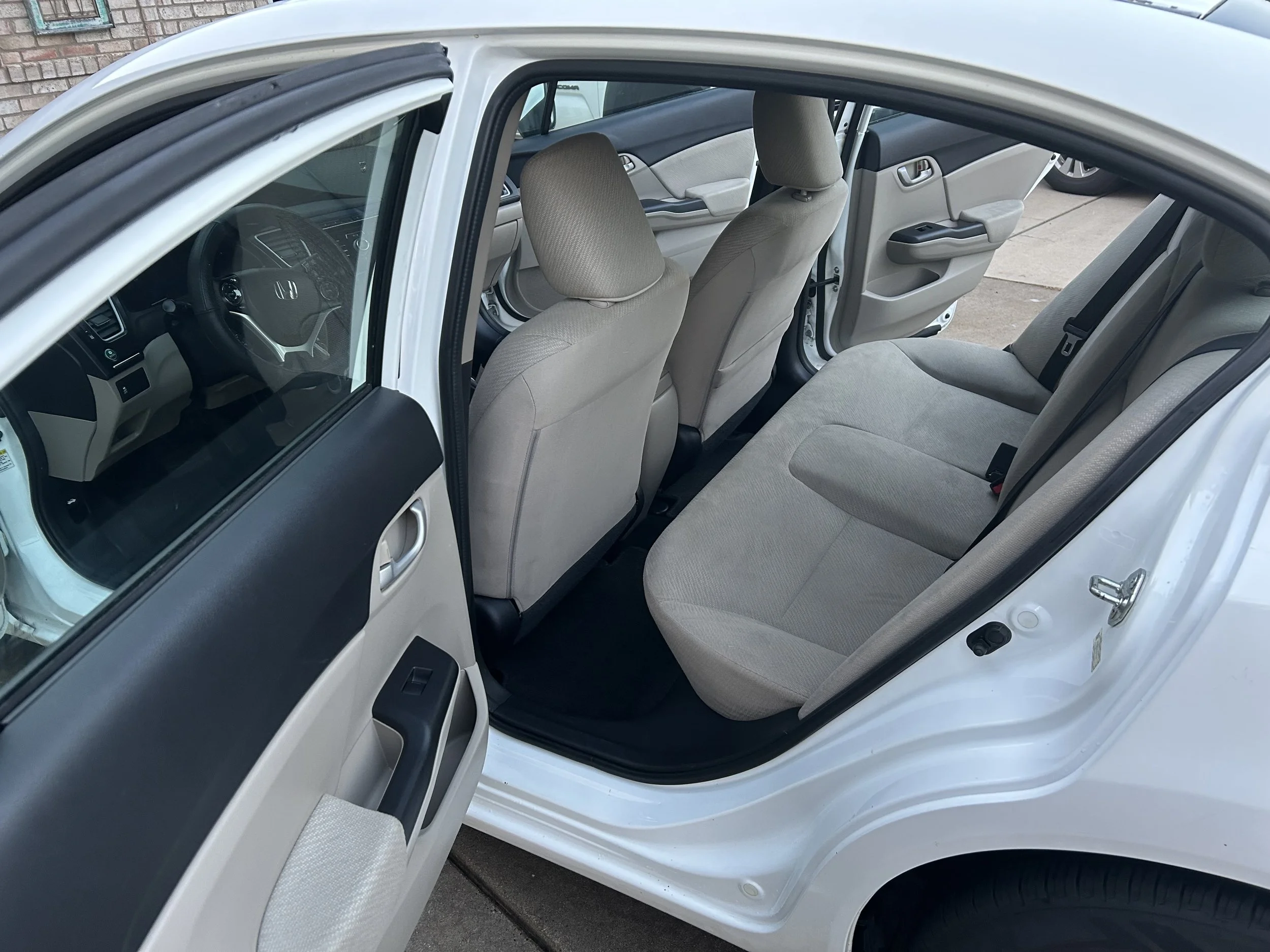Close-up of a vacuum cleaner nozzle cleaning a car's fabric seat.