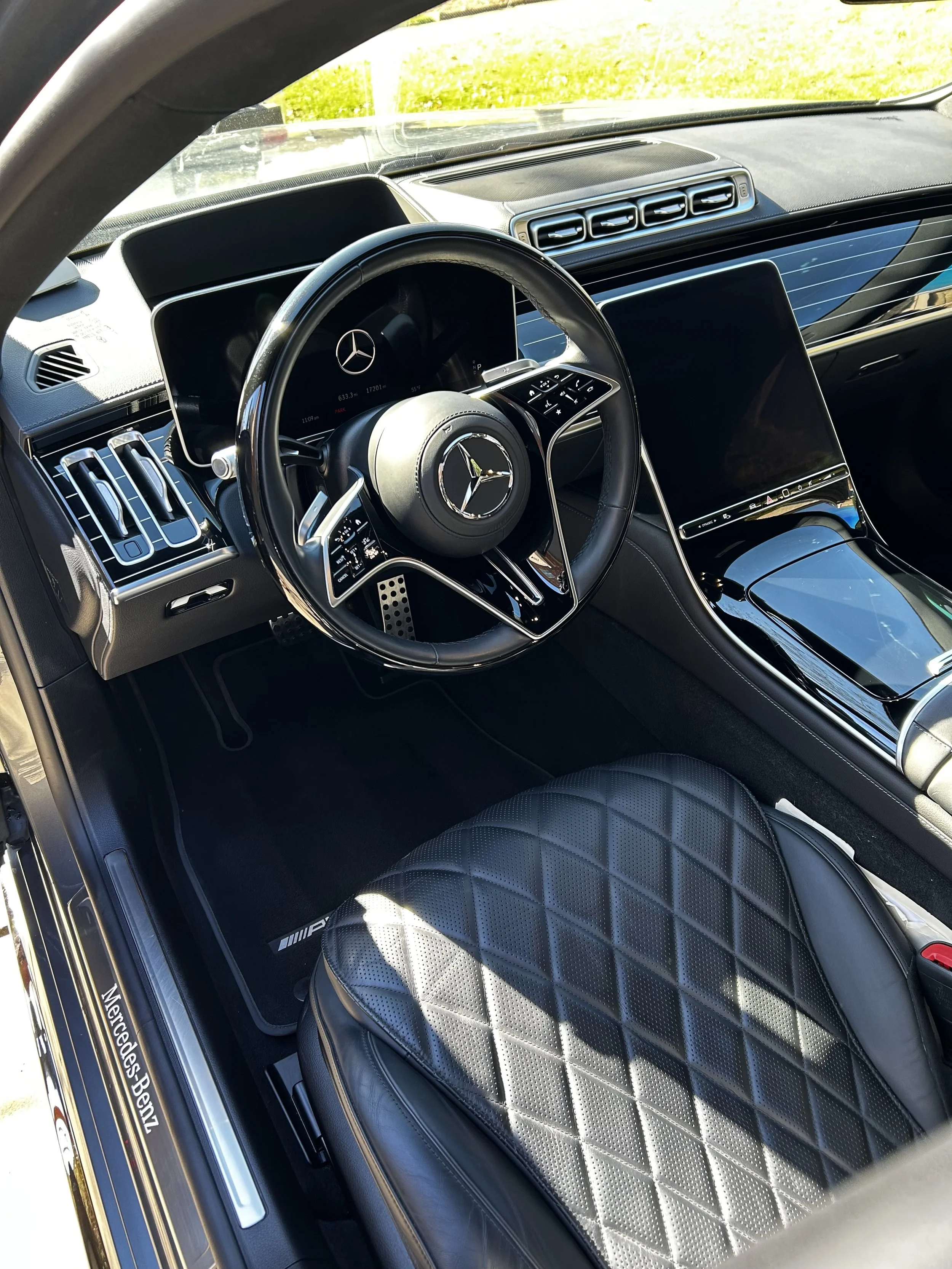 Close-up of a vacuum cleaner nozzle cleaning a car's fabric seat.