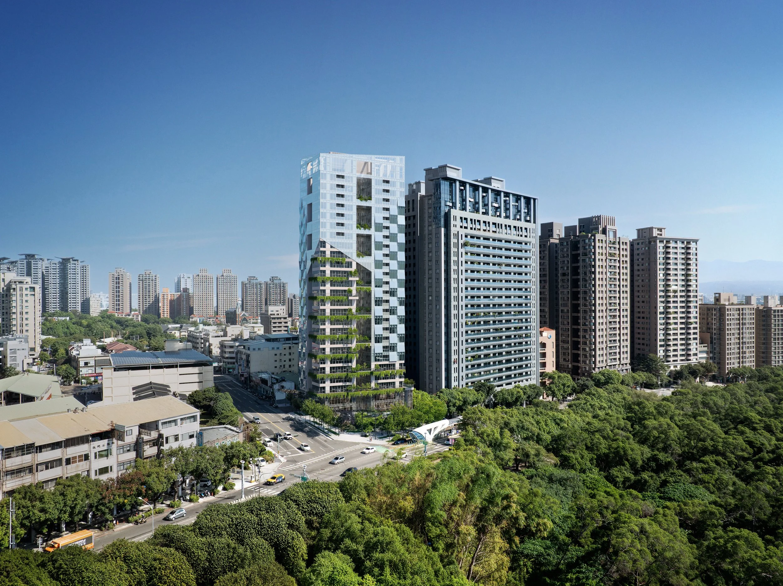 City skyline with modern high-rise buildings and green trees in the foreground on a clear, sunny day.