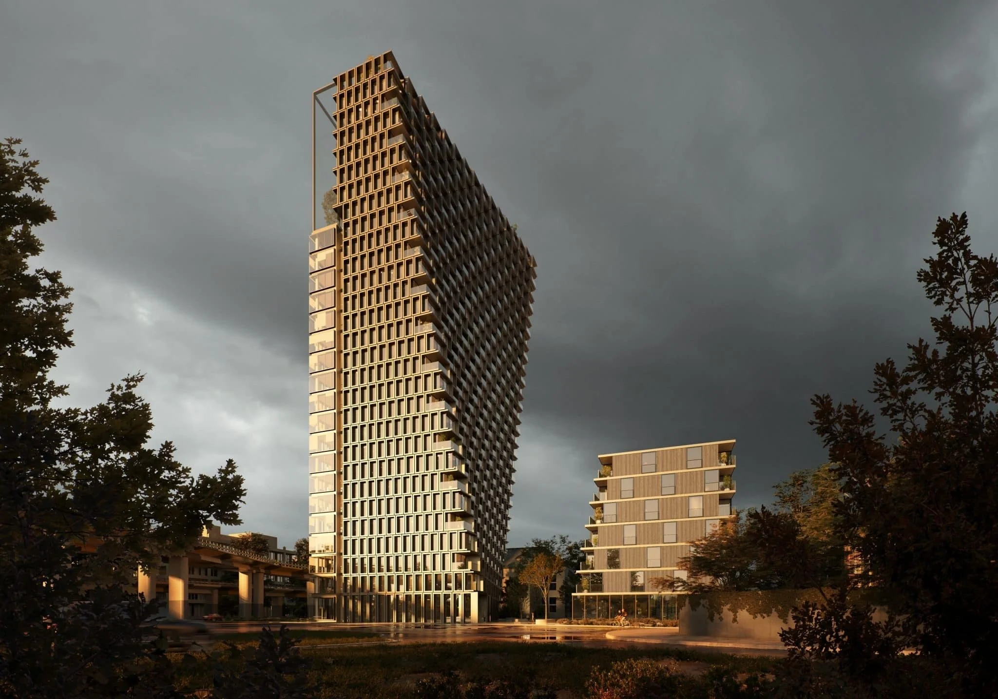 A modern high-rise building with a unique curved design standing tall against a dark, cloudy sky, surrounded by trees and smaller buildings.