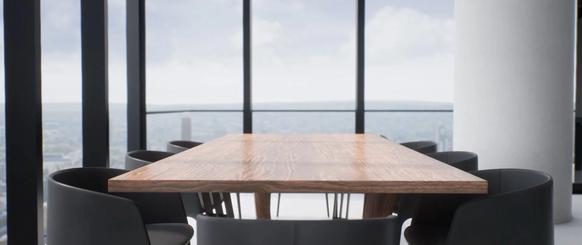A conference room with a wooden table surrounded by black chairs, large windows with a city view, and a cloudy sky outside.