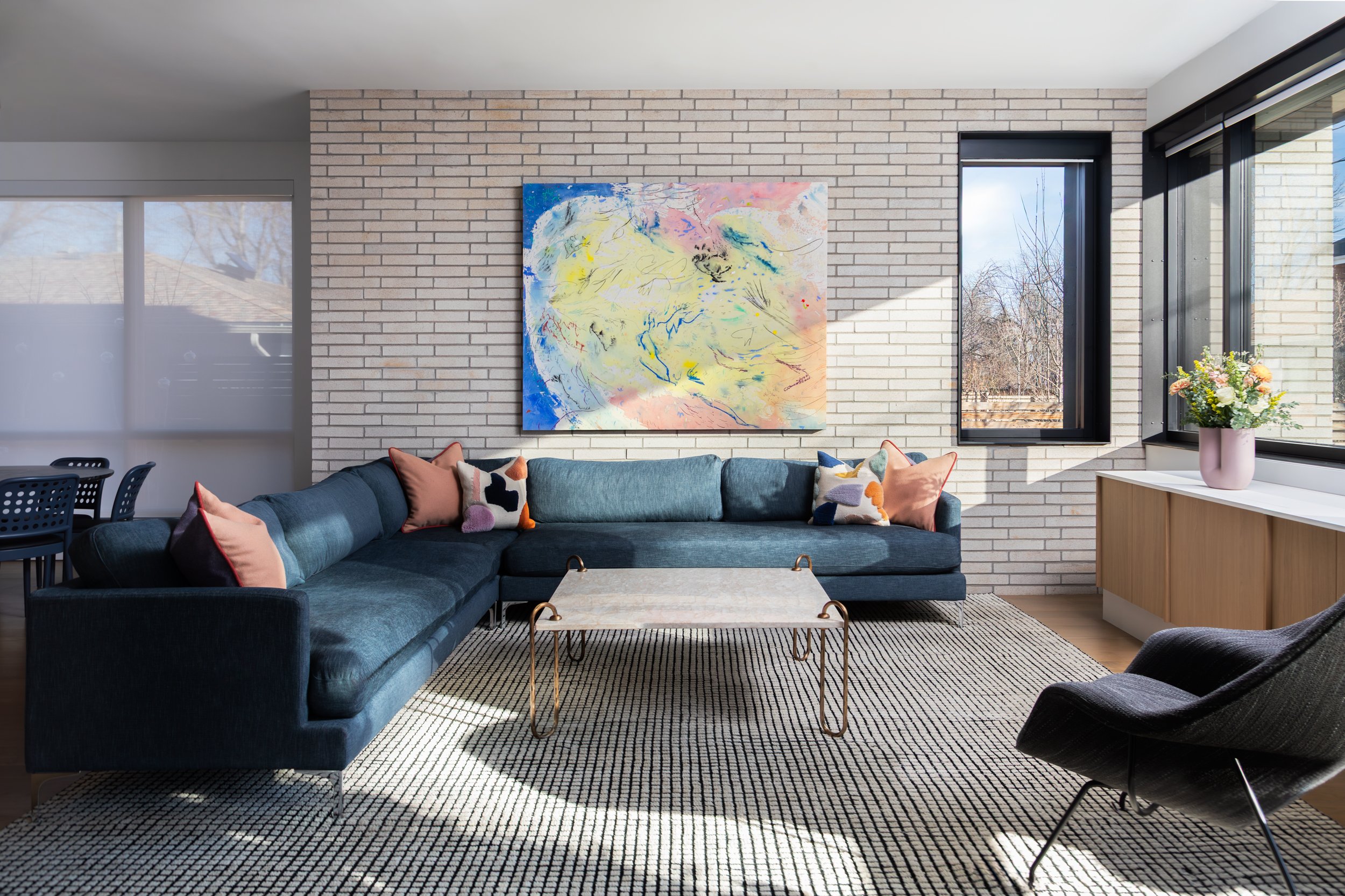 A large abstract landscape painting by New York-based artist Brian Rattiner hangs over a blue couch in Boulder, Colorado.