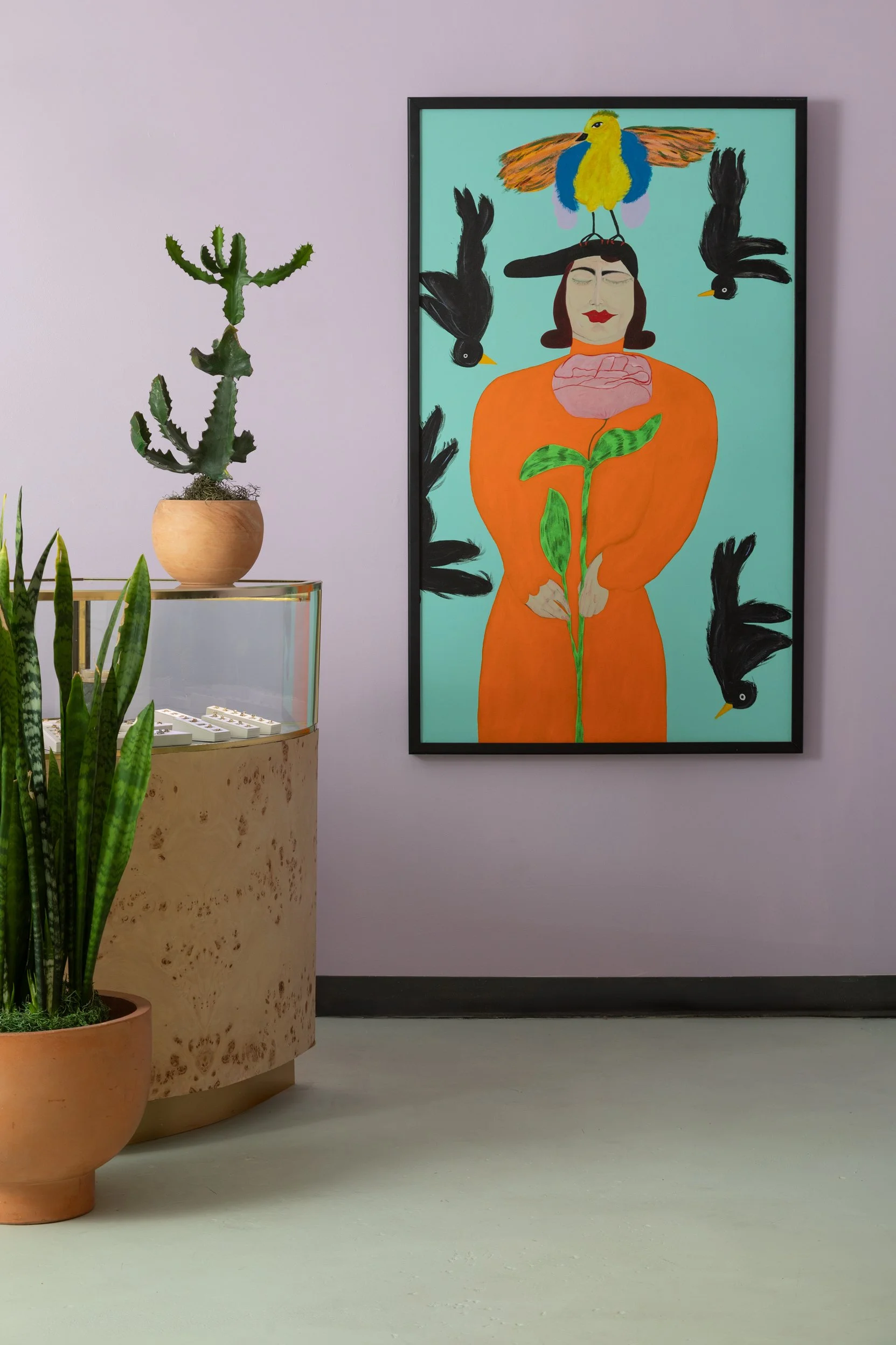 A painting of a woman with birds, by Denver artist Susan Wick, hangs in the Young in the Mountains studio.