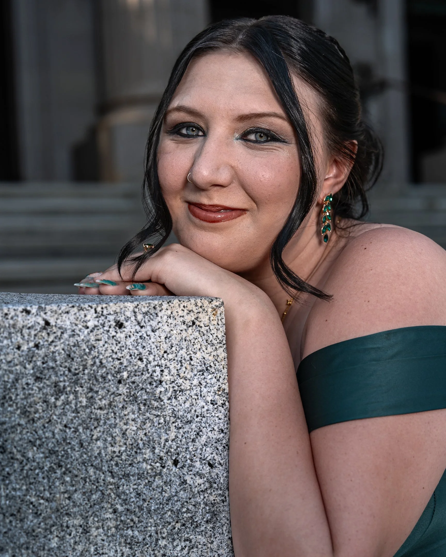 A photograph of a young woman on prom night in a green dress and beautiful makeup in woodland, California