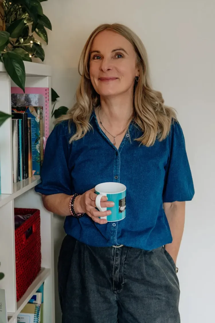 Sophie Longden standing holding a cup of Yorkshire tea smiling