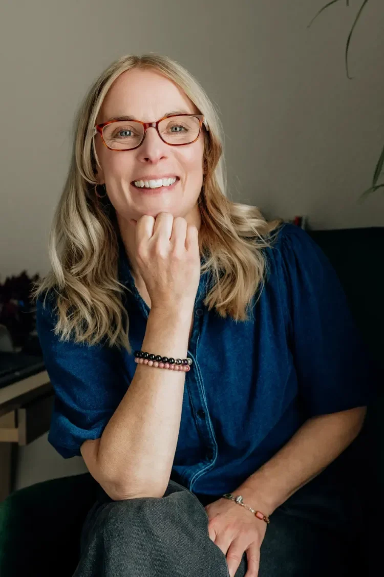 Sophie Longden, Greater Manchester therapist smiling resting her chin on her hand