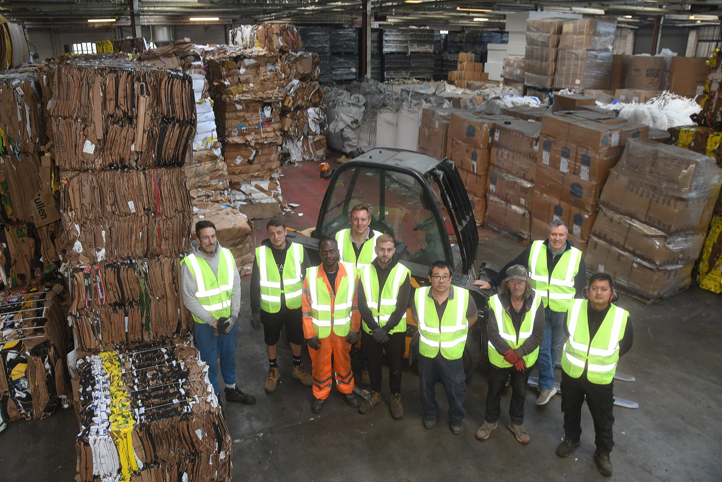 Image of the wharehouse operations team at Regenthill recycling with cardboard box bales around