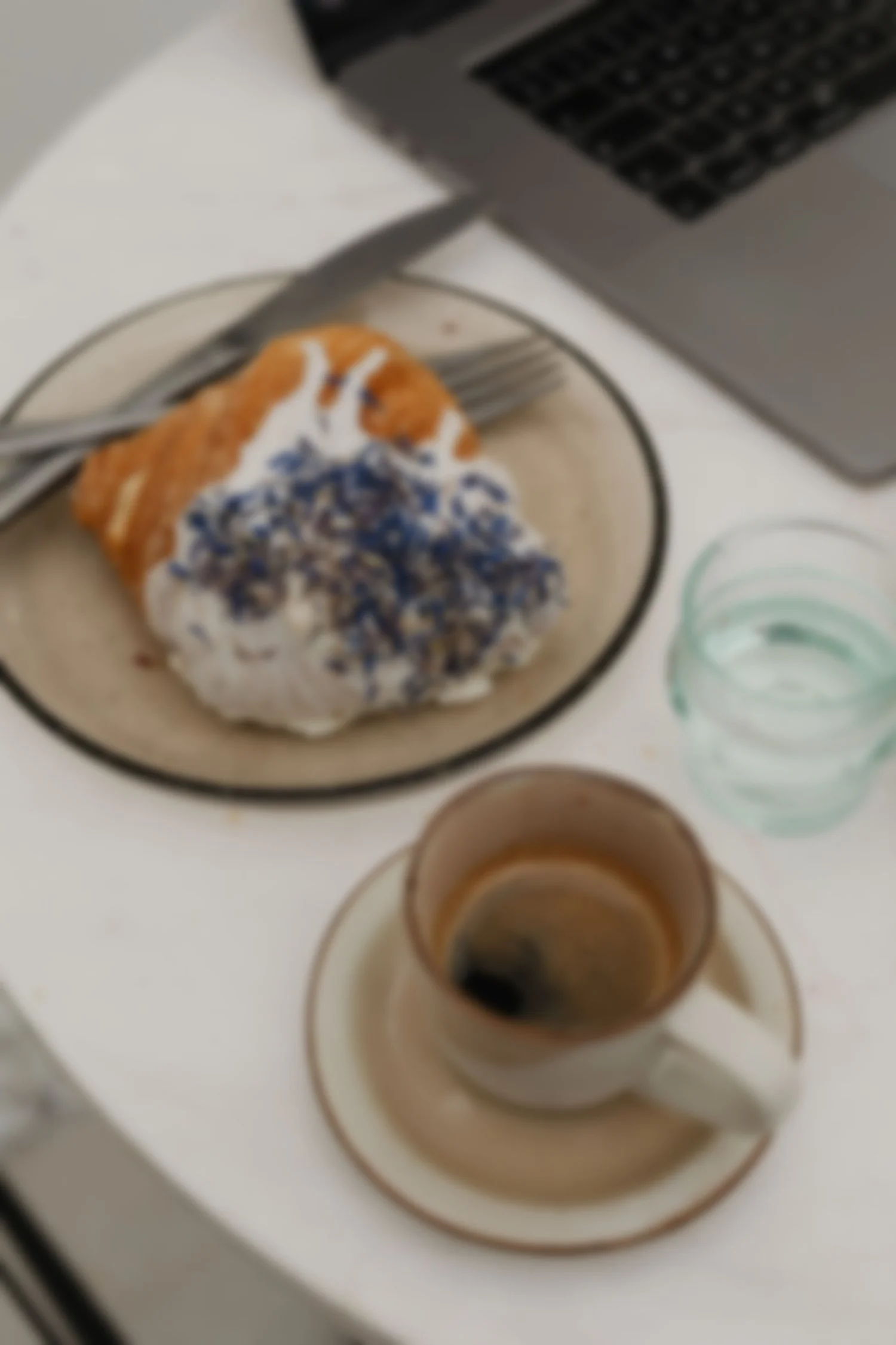 neutral cafe workspace with laptop and croissant