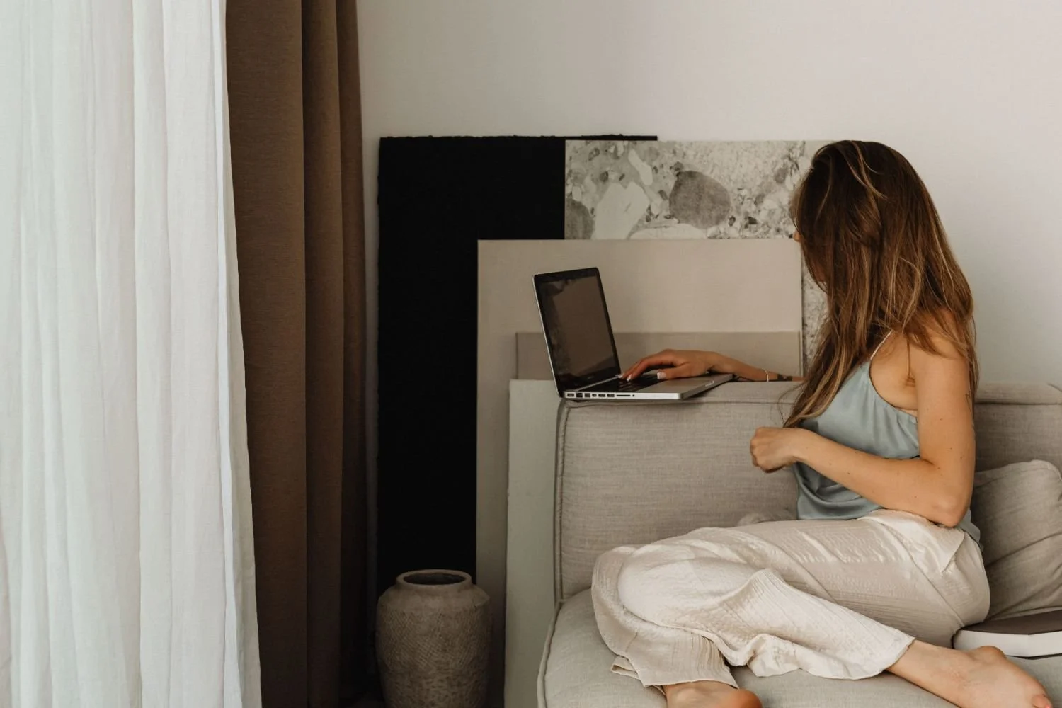 woman looking at designs while using laptop