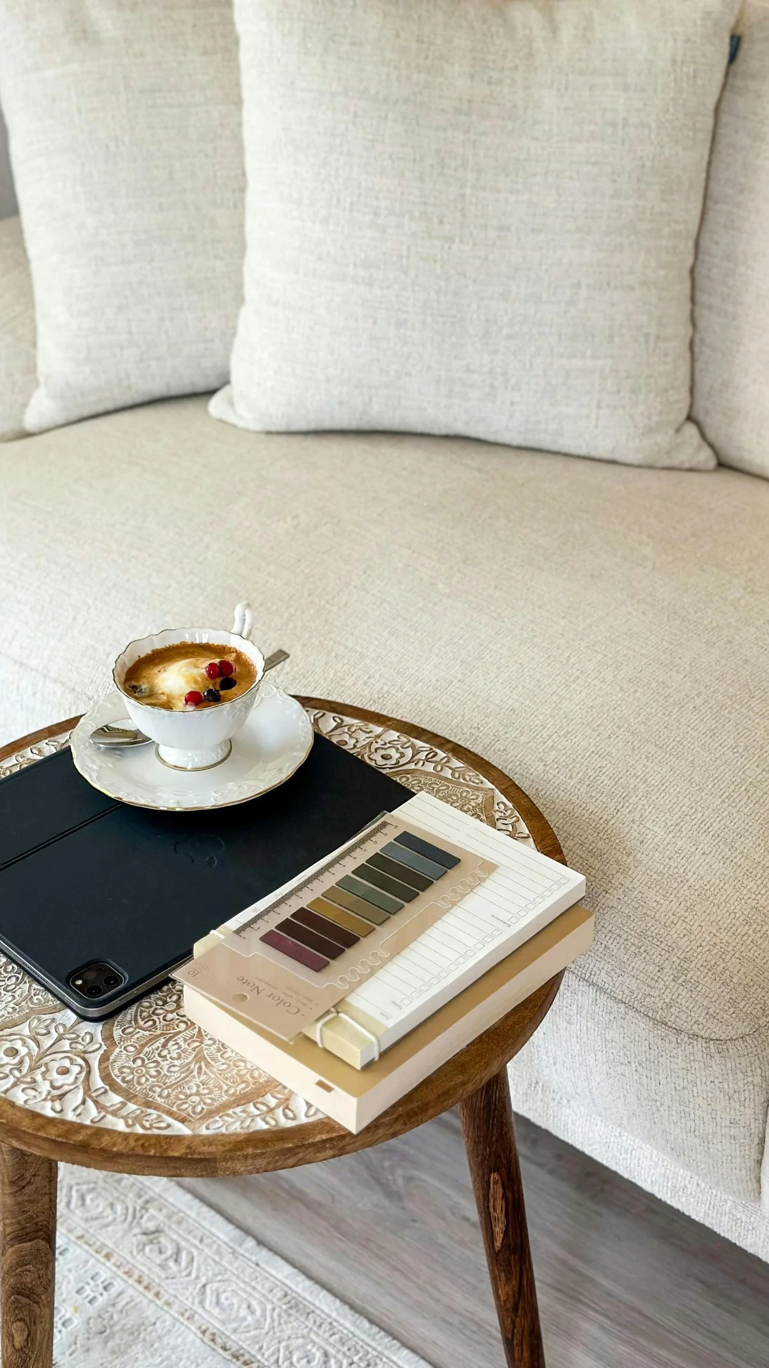 couch with side table with coffee and design notebooks