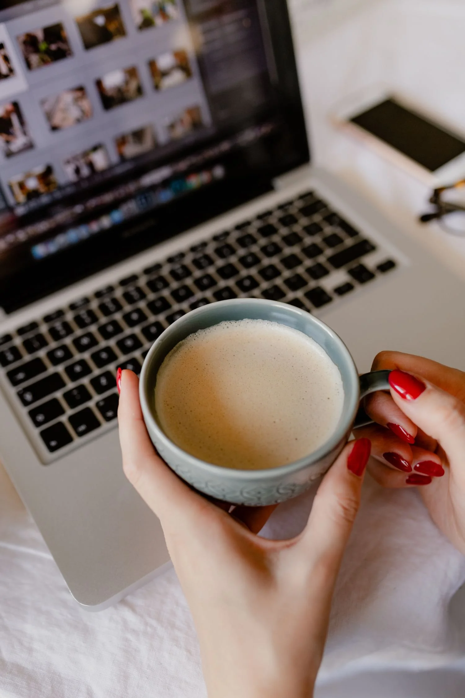 woman working on laptop with cell phone and coffee