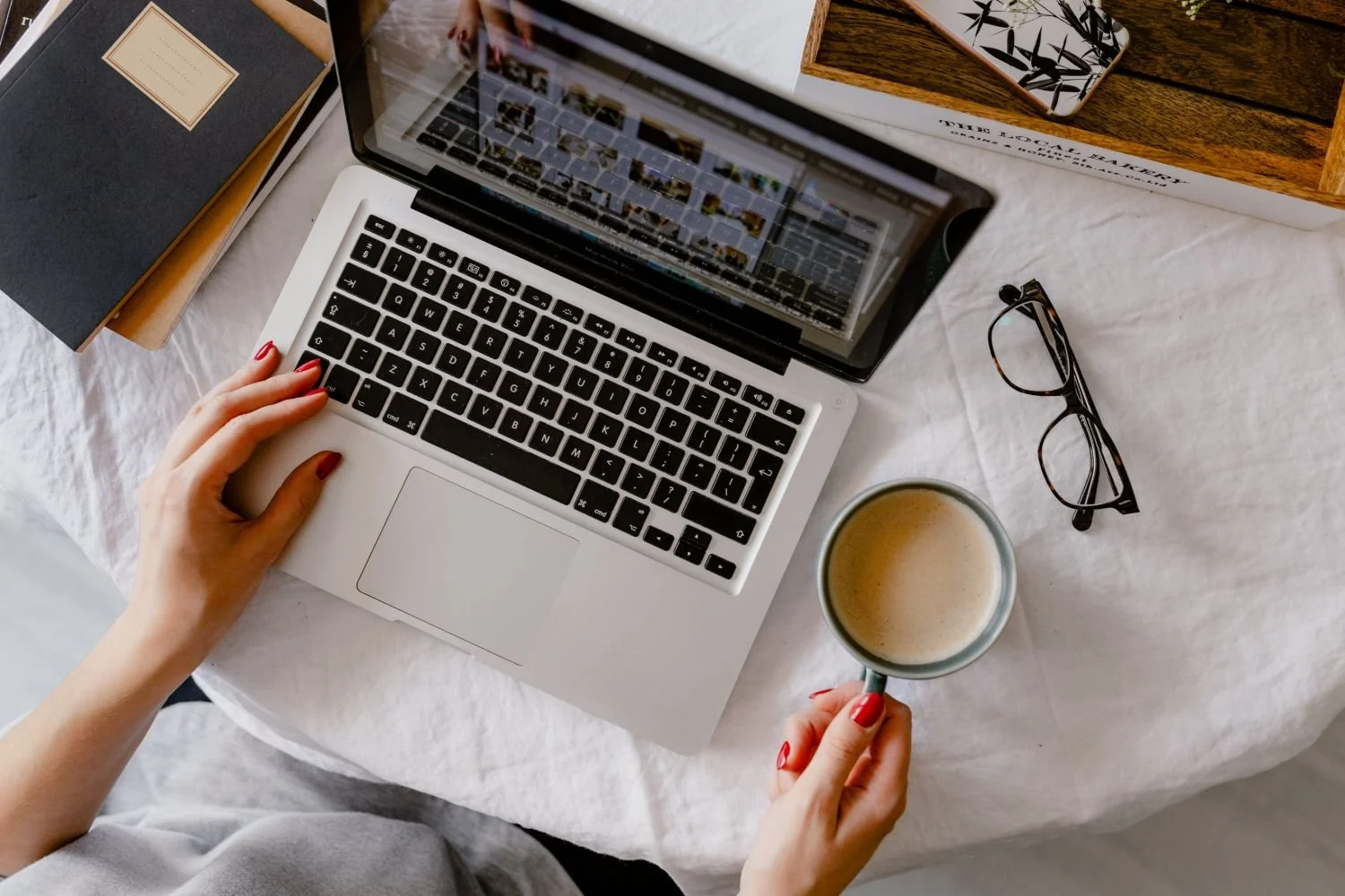 top down view of someone on a laptop with glasses and coffee nearby