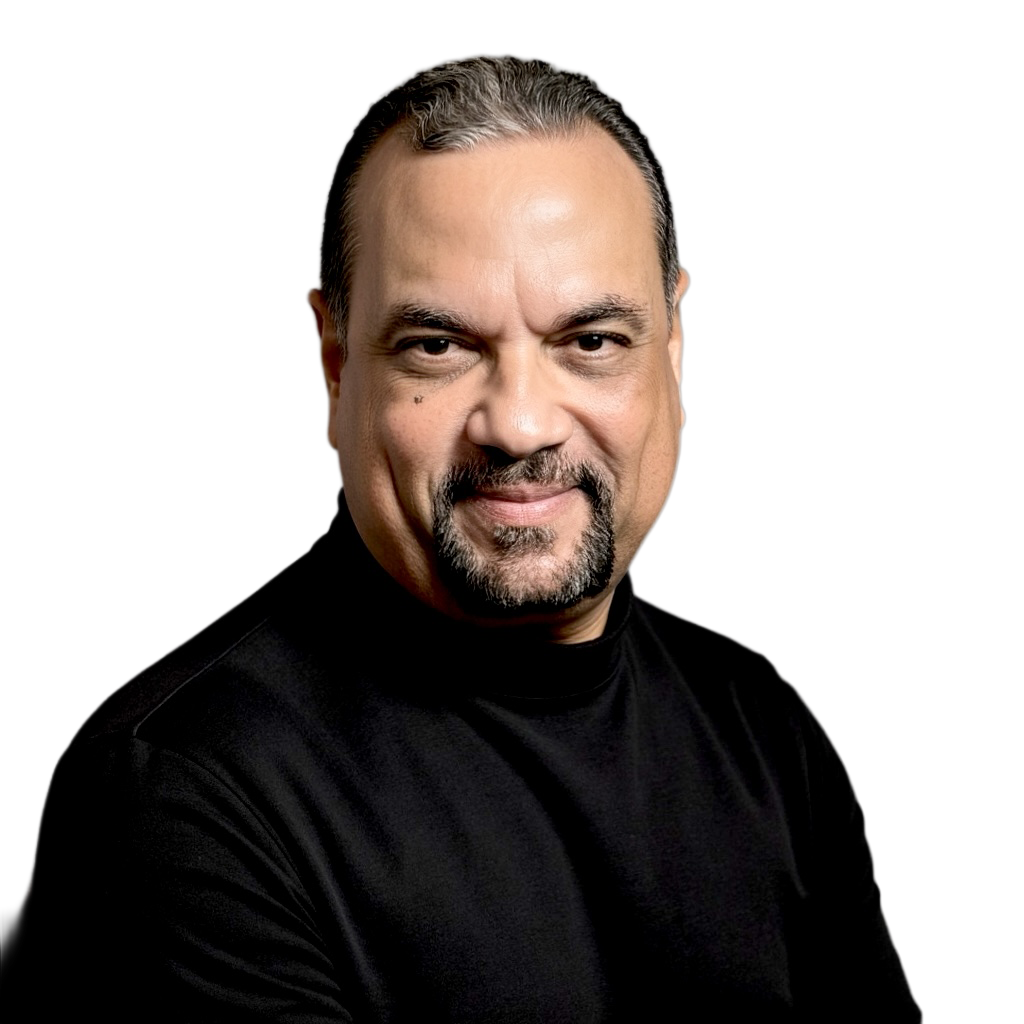 Close-up portrait of a middle-aged man with short dark hair, a goatee, wearing a black shirt, smiling against a digital background.