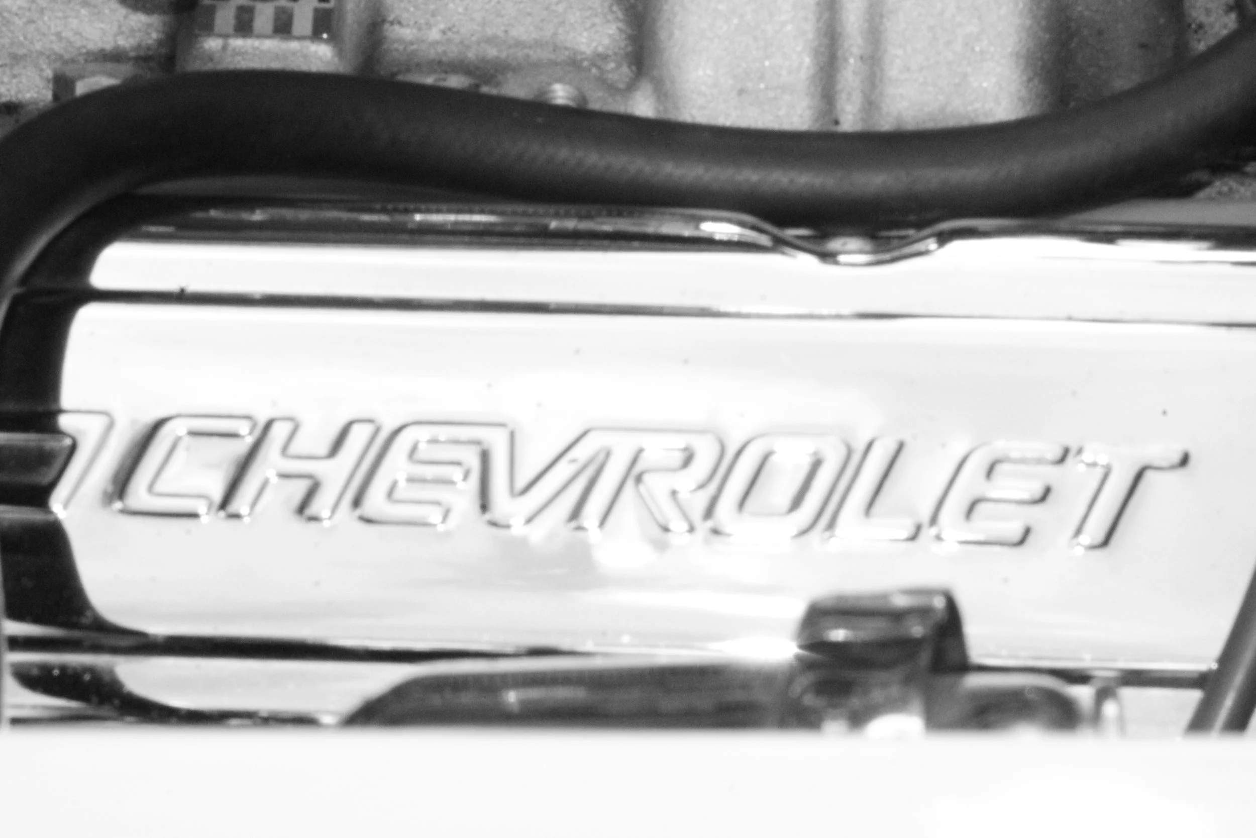 Close-up of a Chevrolet vehicle badge on the front grille in black and white, with the Chevrolet logo visible.