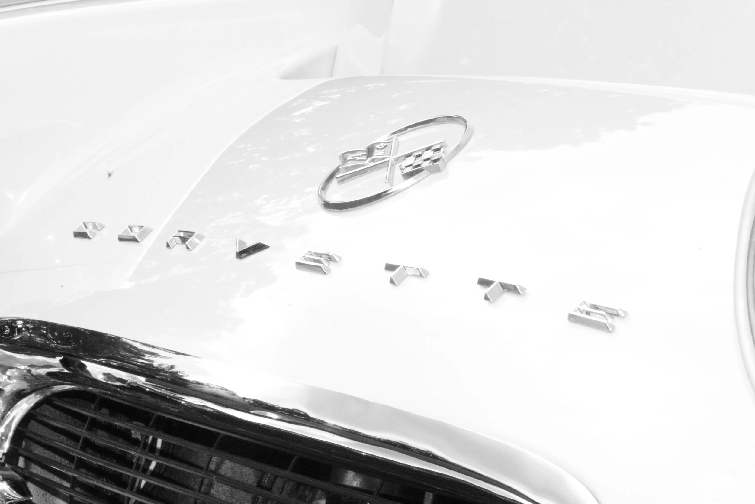 Close-up of the front of a Chevrolet Corvette with a Corvette emblem and chrome lettering.