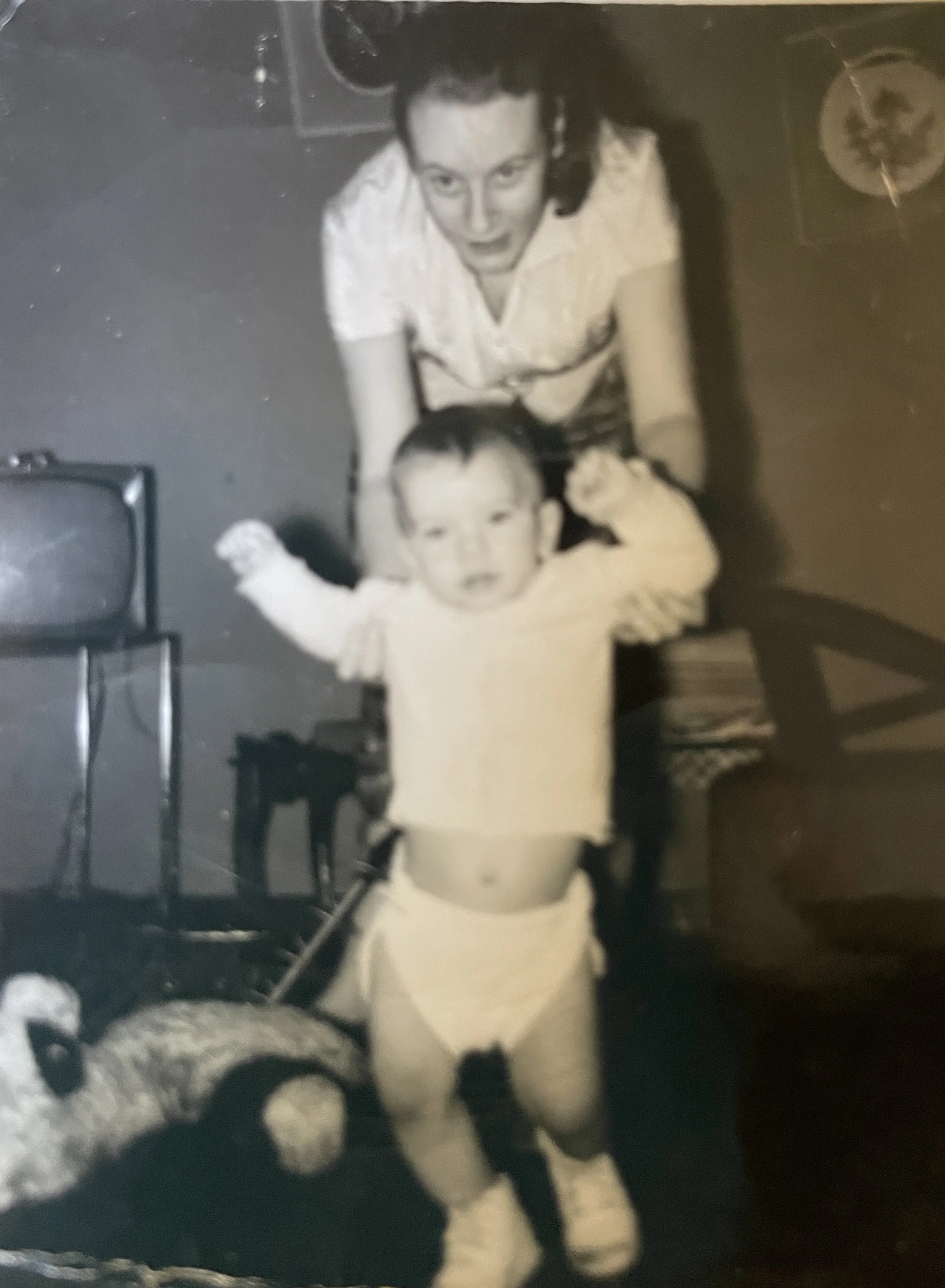 A woman and a young child are looking up at the camera, with the woman smiling and the child making a playful expression; the photo appears to be taken from above.
