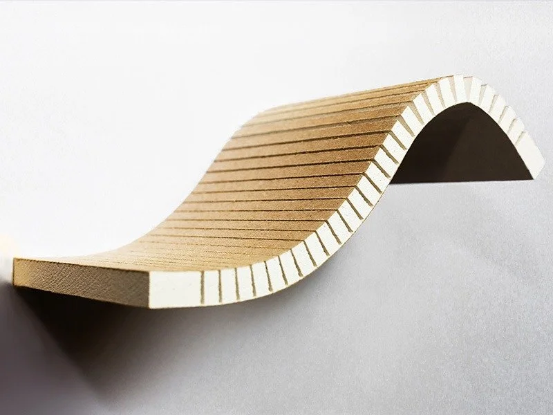 Manipulated gypsum panel with a curved shape on a plain white background.