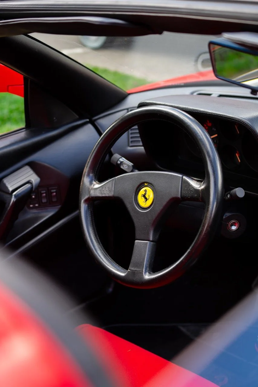 Interno di un'auto sportiva Ferrari con volante con logo del cavallino rampante
