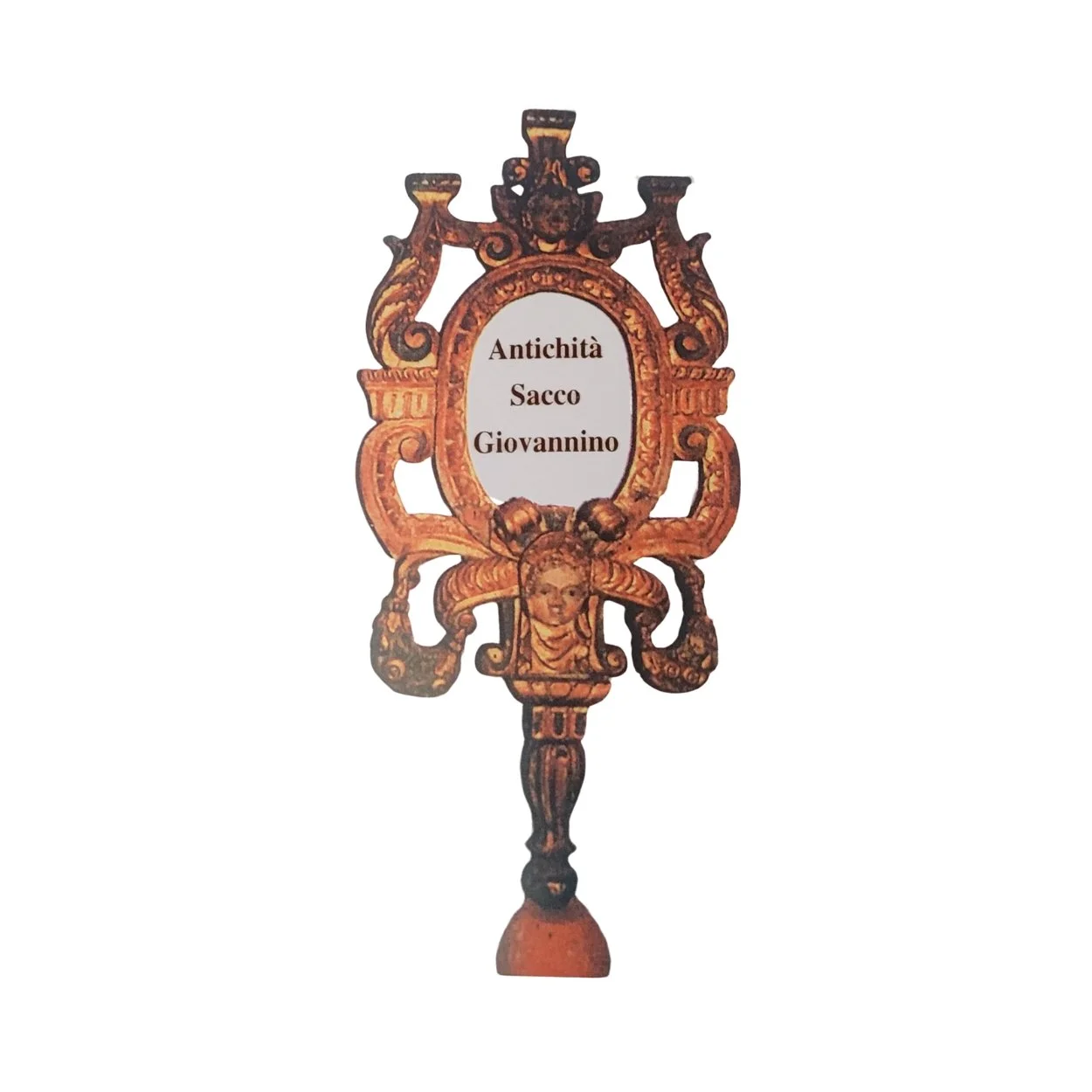 Ornate antique handheld mirror with a carved wooden frame featuring a face and floral designs, displayin the words 'Antichità Sacco Giovannino' on its reflective surface.