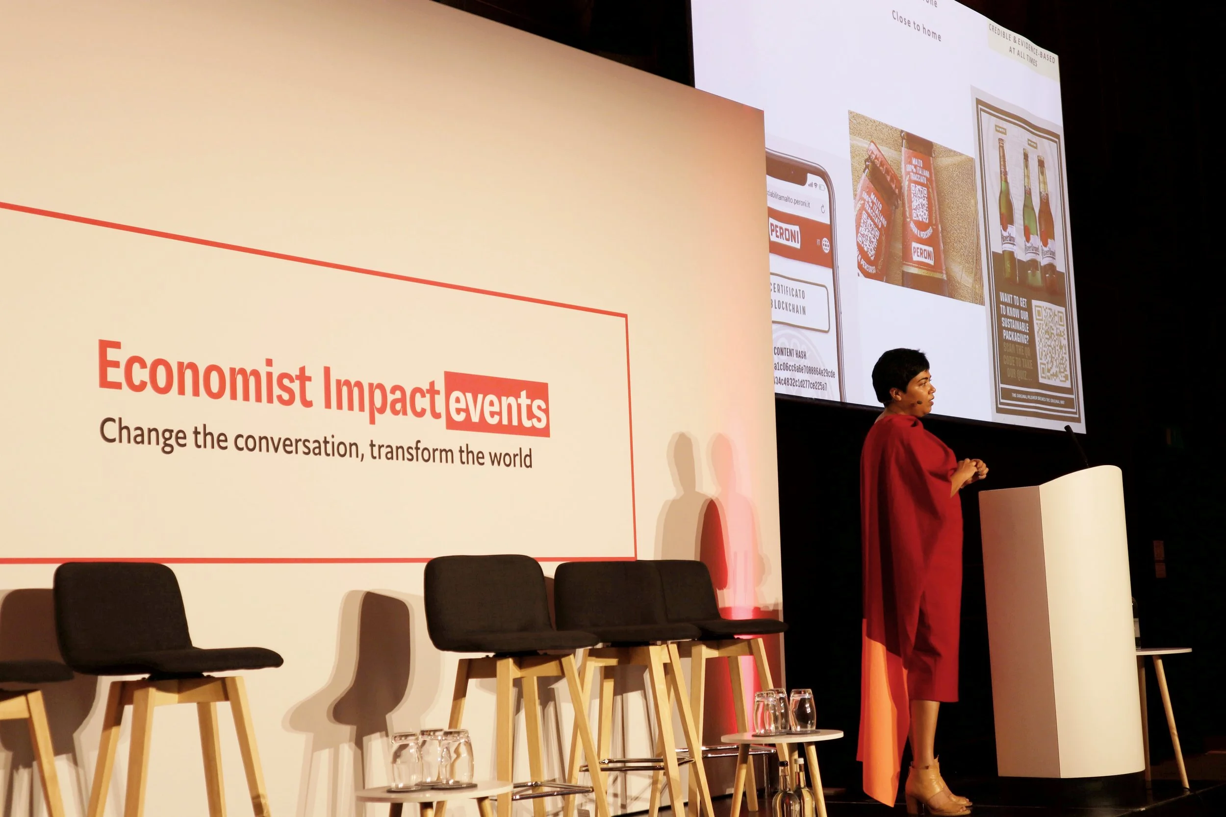 Preeti Srivastav giving a presentation on a stage at Economist Impact events.