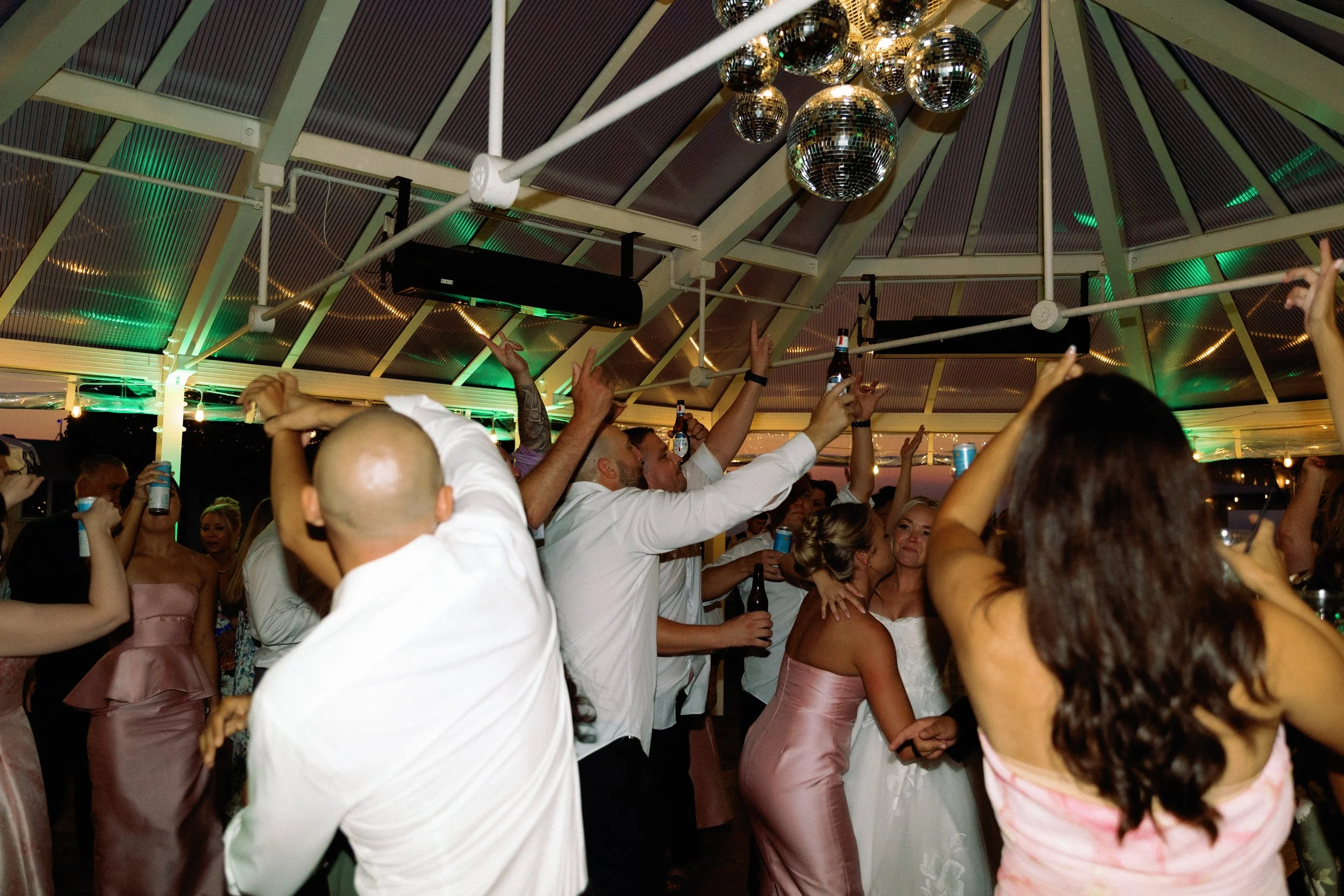Wedding guests filling the dance floor during an energetic evening reception at Stafford's Perry Hotel.