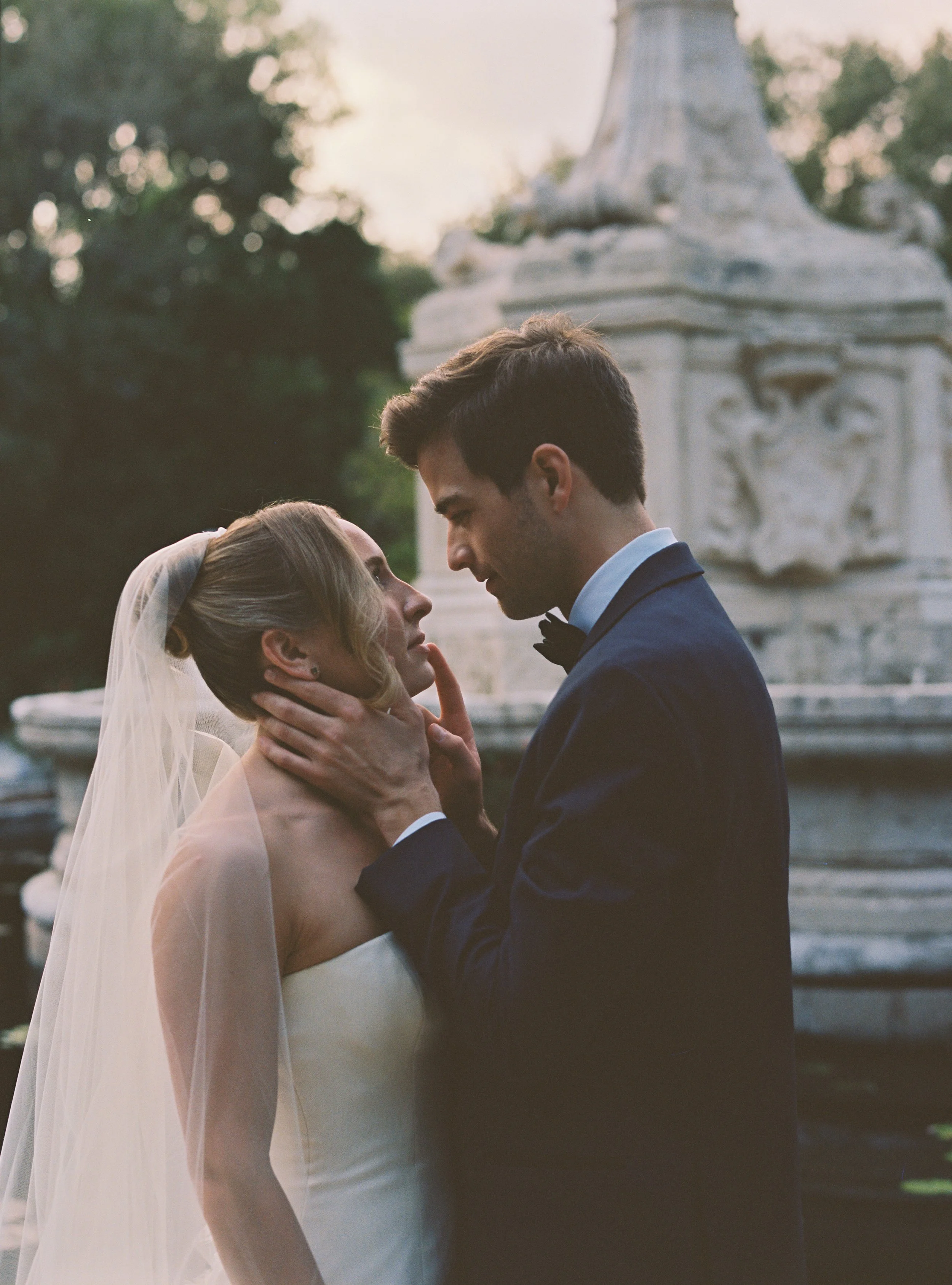 Romantic close-up portrait of the bride and groom holding each other during golden hour in the gardens. (Copy)
