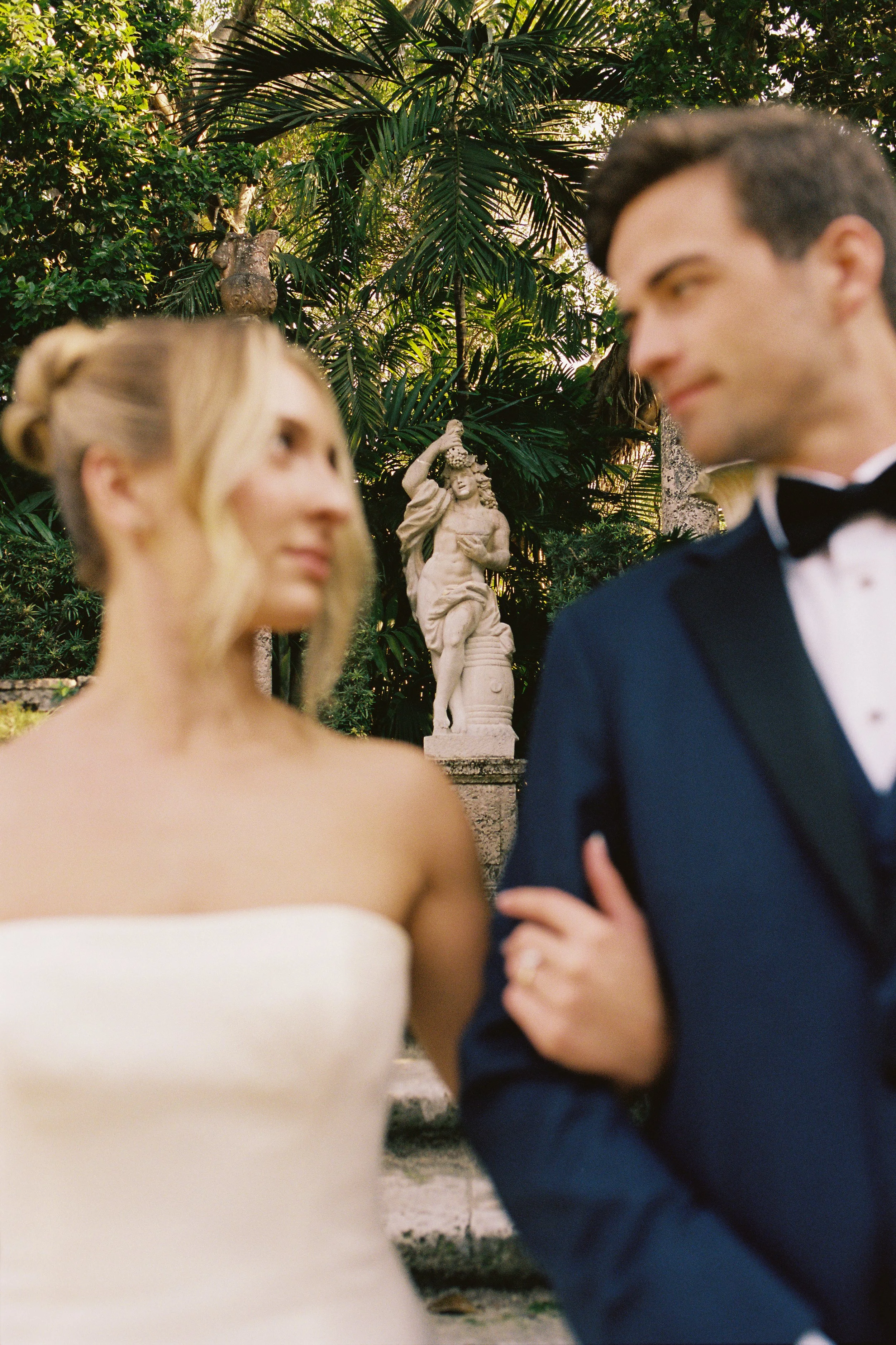 Bride and groom walking arm in arm through the tropical gardens at Vizcaya Museum and Gardens. (Copy)