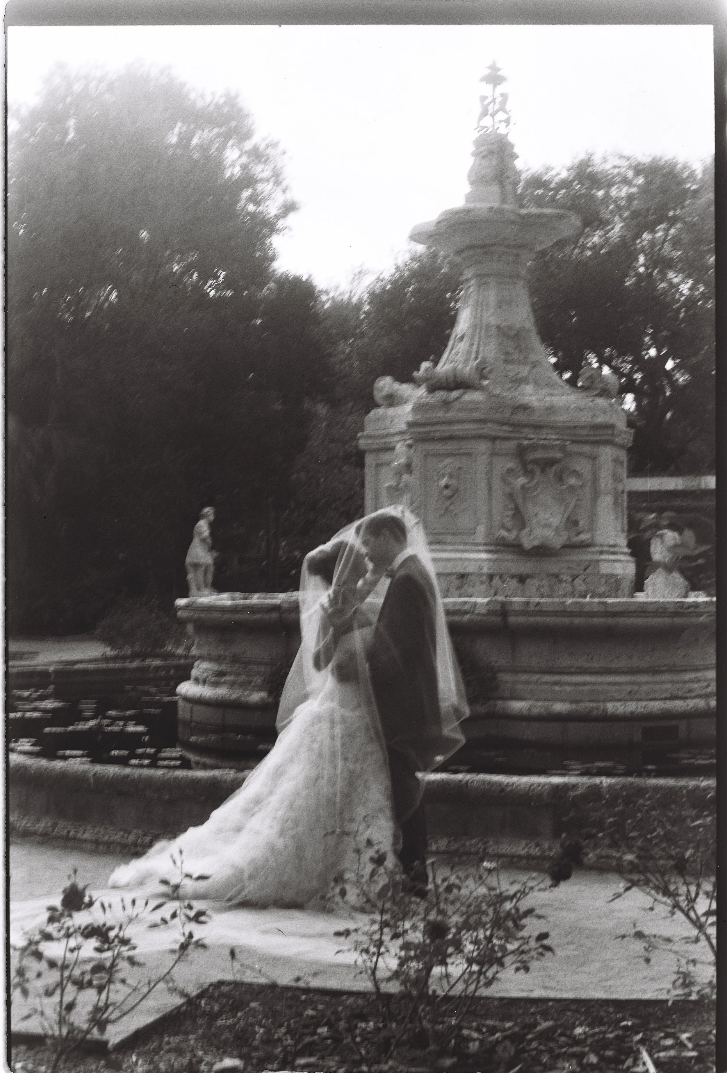 Romantic black and white portrait of the bride and groom embracing beside the historic fountain at Vizcaya Museum and Gardens. (Copy)