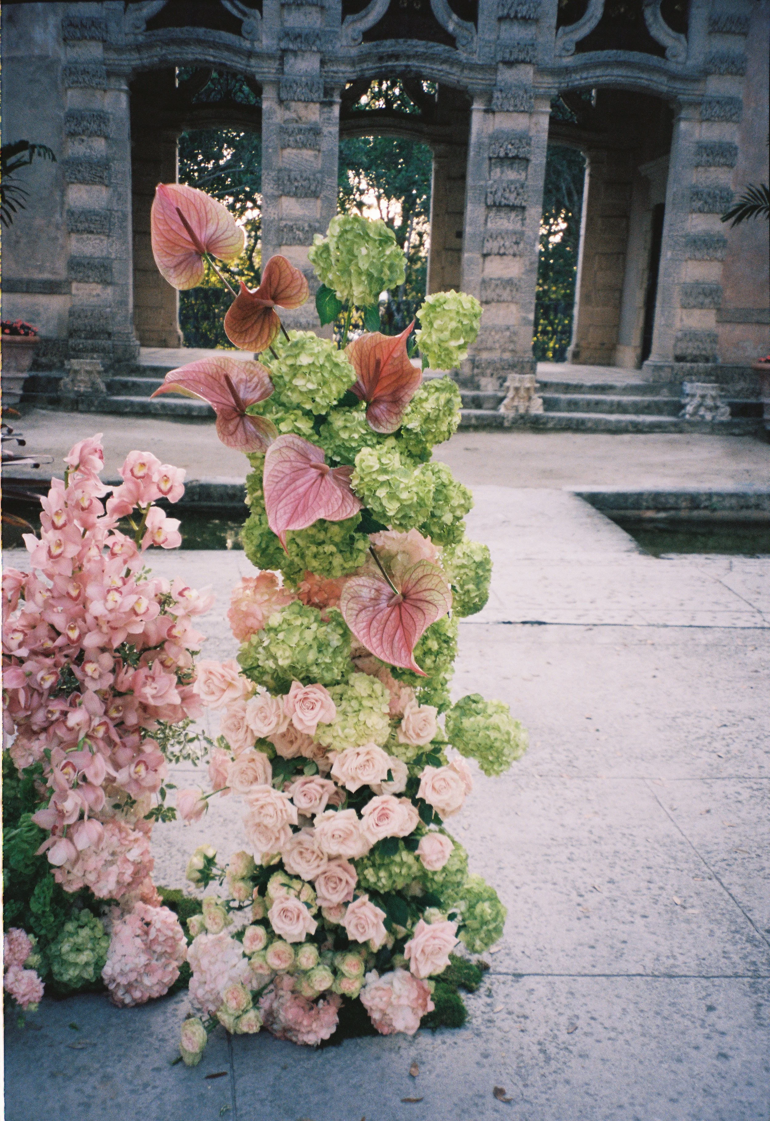 Colorful ceremony floral installation with anthuriums, roses, and hydrangeas set in the courtyard of Vizcaya Museum and Gardens. (Copy)