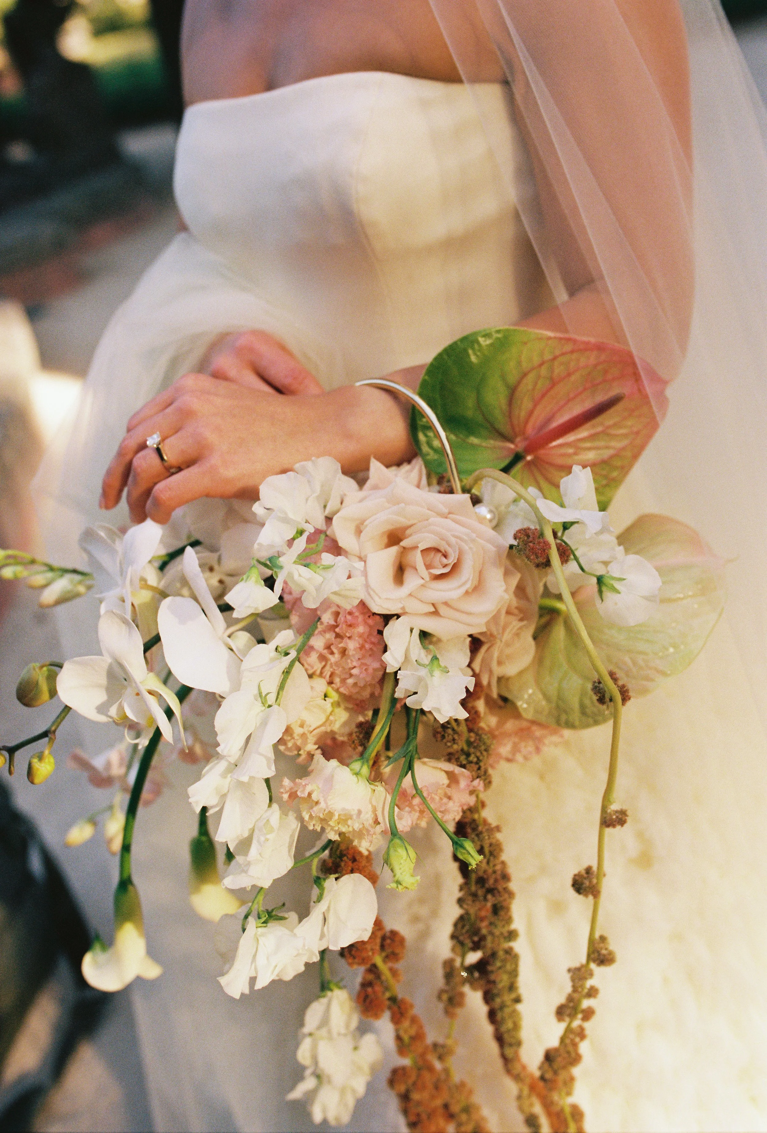 Bride holding her bouquet of orchids and roses while showing her engagement ring. (Copy)