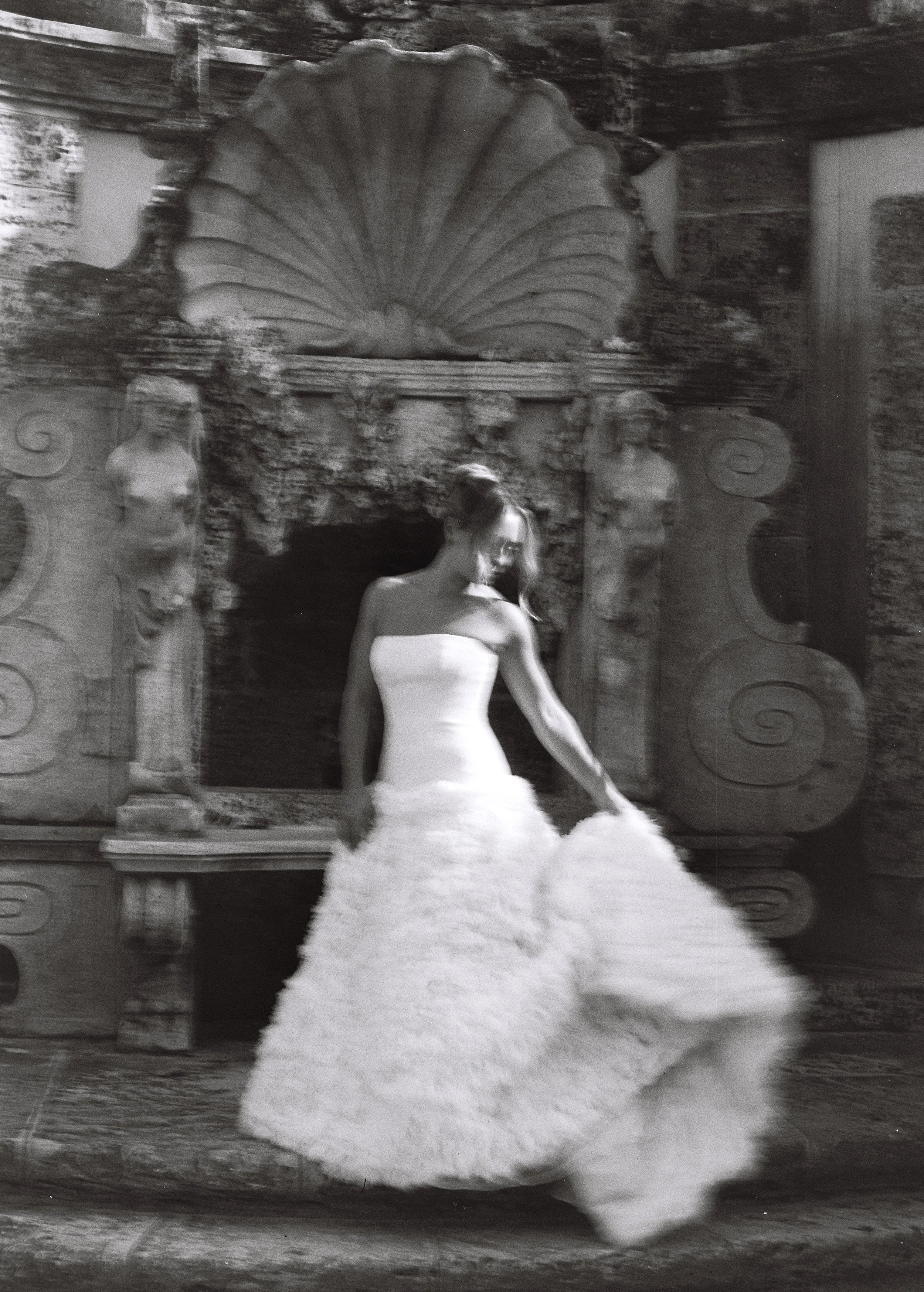 Bride in a textured strapless wedding gown moving gracefully in front of the historic stone fountain at Vizcaya Museum and Gardens. (Copy)
