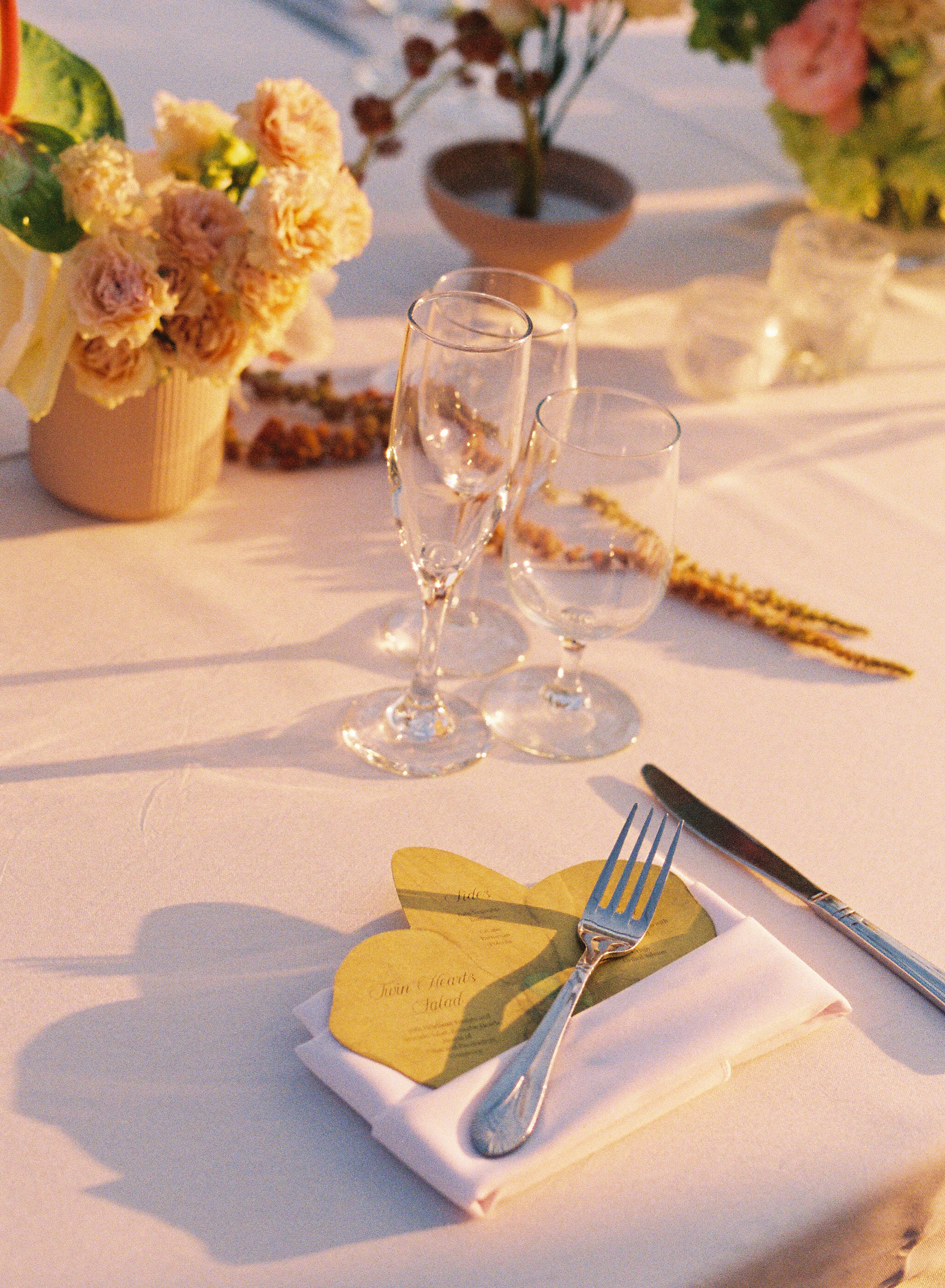 Elegant reception table details with floral centerpieces, glassware, and golden light during a Vizcaya Museum and Gardens wedding. (Copy)
