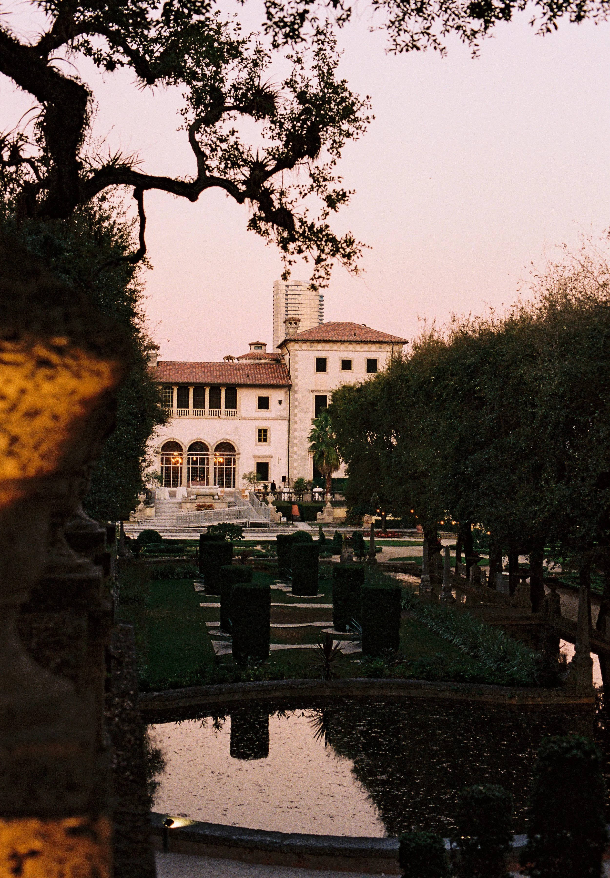 Sunset view of the historic Vizcaya Museum and Gardens estate with its Mediterranean-style villa, manicured gardens, and reflecting pool. (Copy)