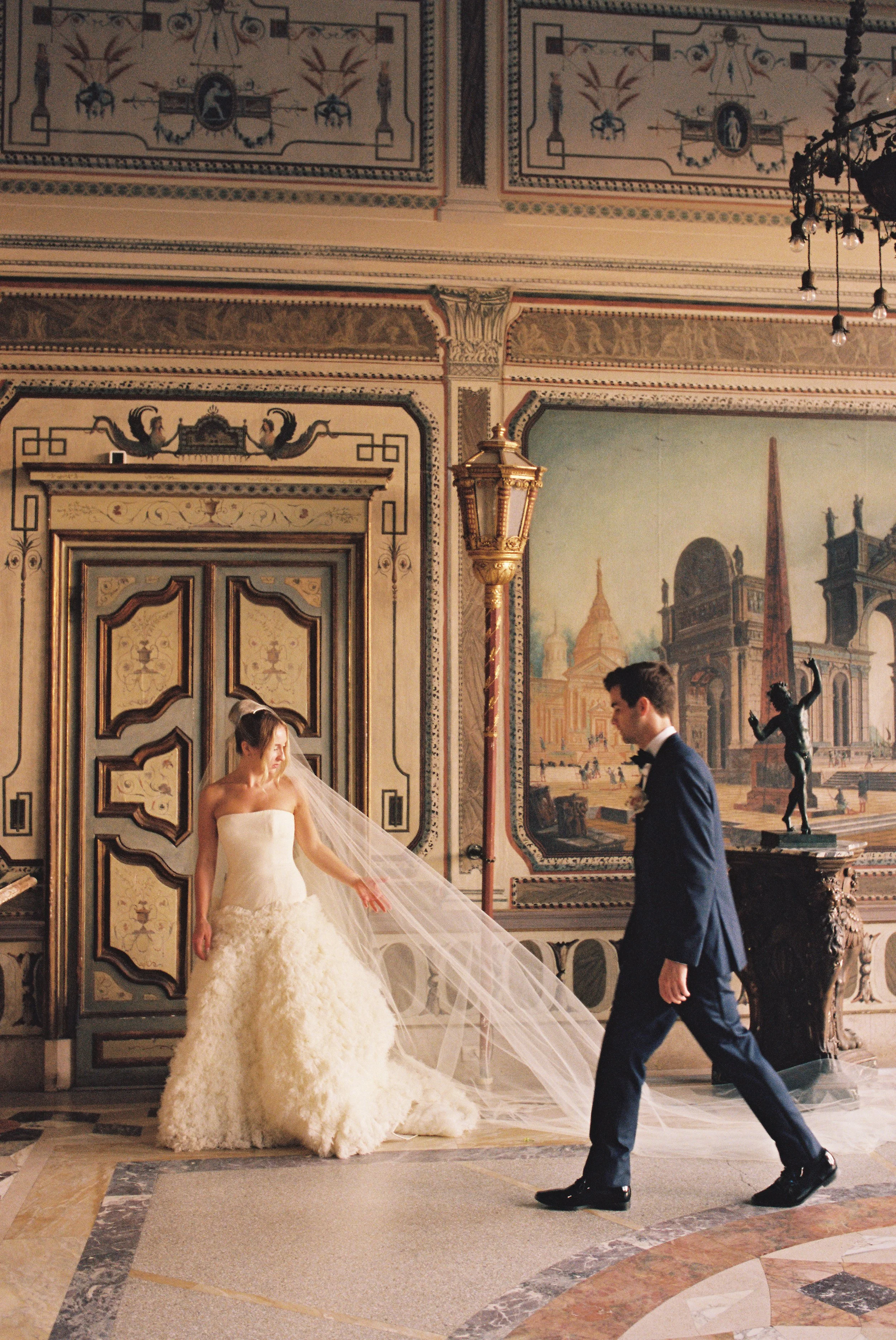 Bride and groom walking together inside the historic villa interior with ornate painted walls and marble floors at Vizcaya Museum and Gardens. (Copy)