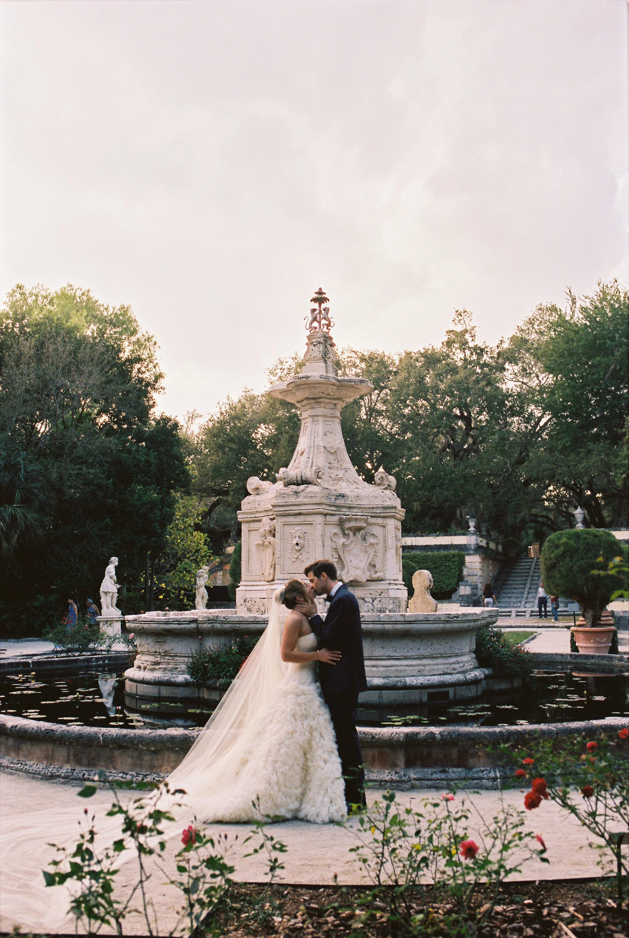 Bride and groom kiss next to a fountain (Copy)