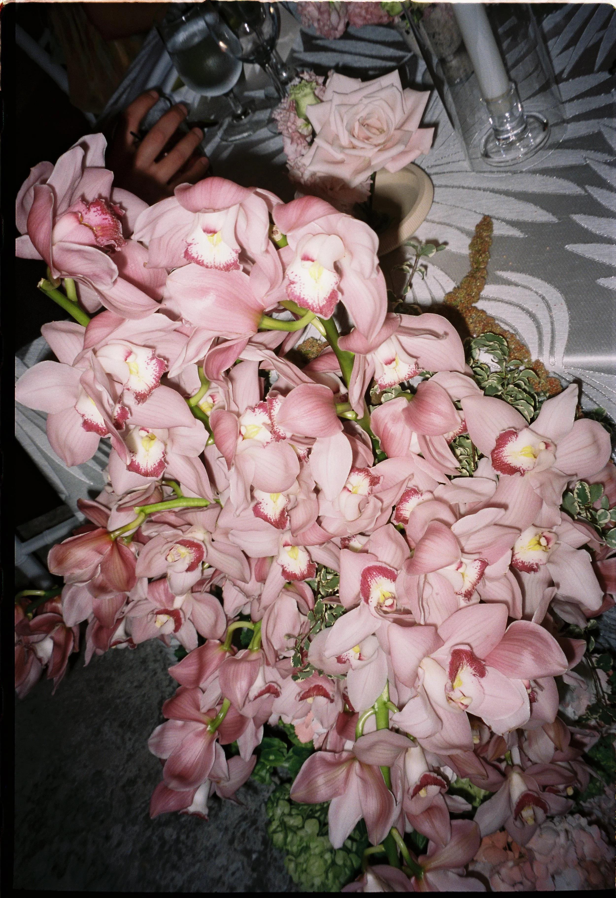 Pink orchid wedding florals arranged on a reception table with candlelight and soft romantic styling during a Vizcaya Museum and Gardens wedding.
