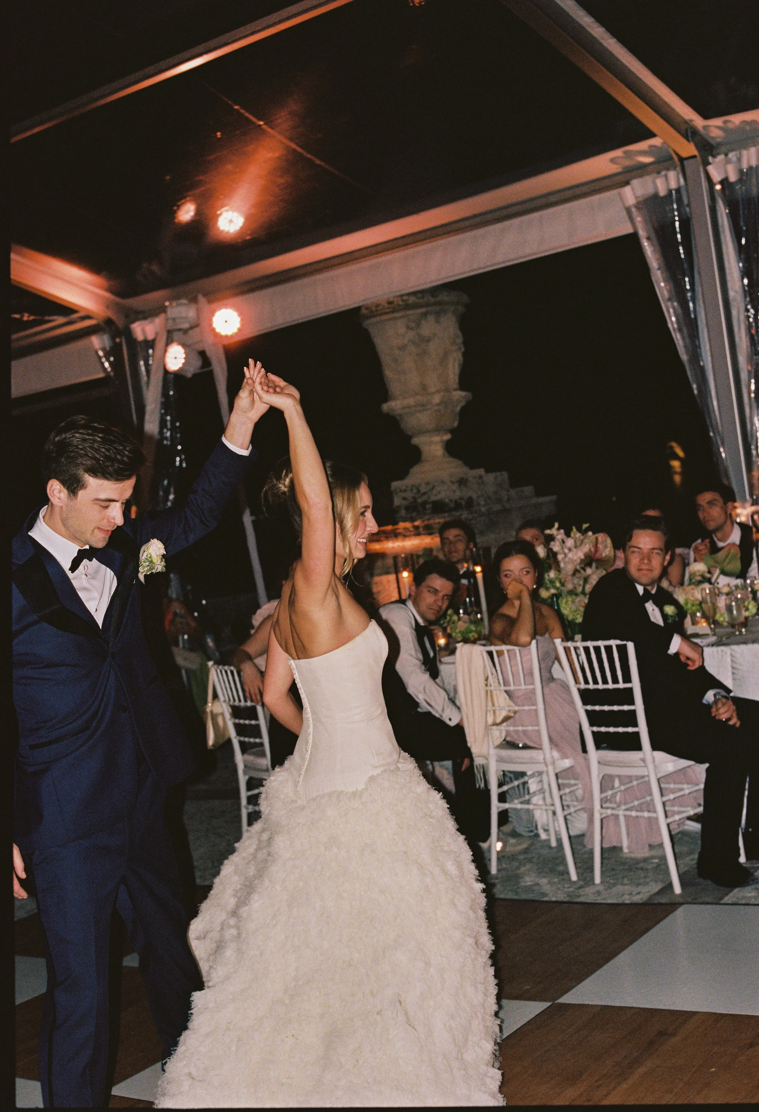 Bride and groom sharing their first dance under a clear reception tent surrounded by guests during a Vizcaya Museum and Gardens wedding reception.