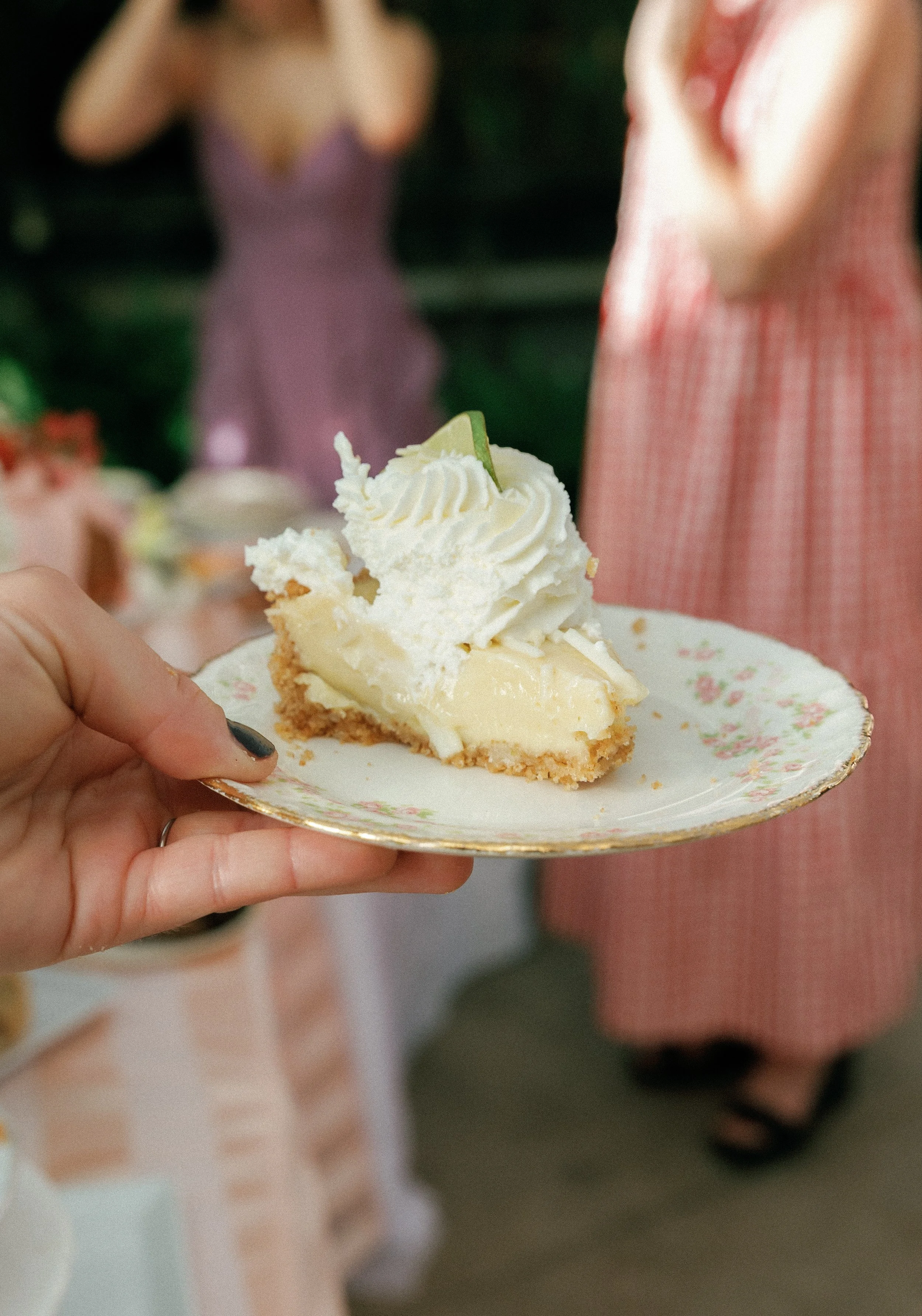 Close-up of a slice of creamy pie with whipped topping held on a vintage plate