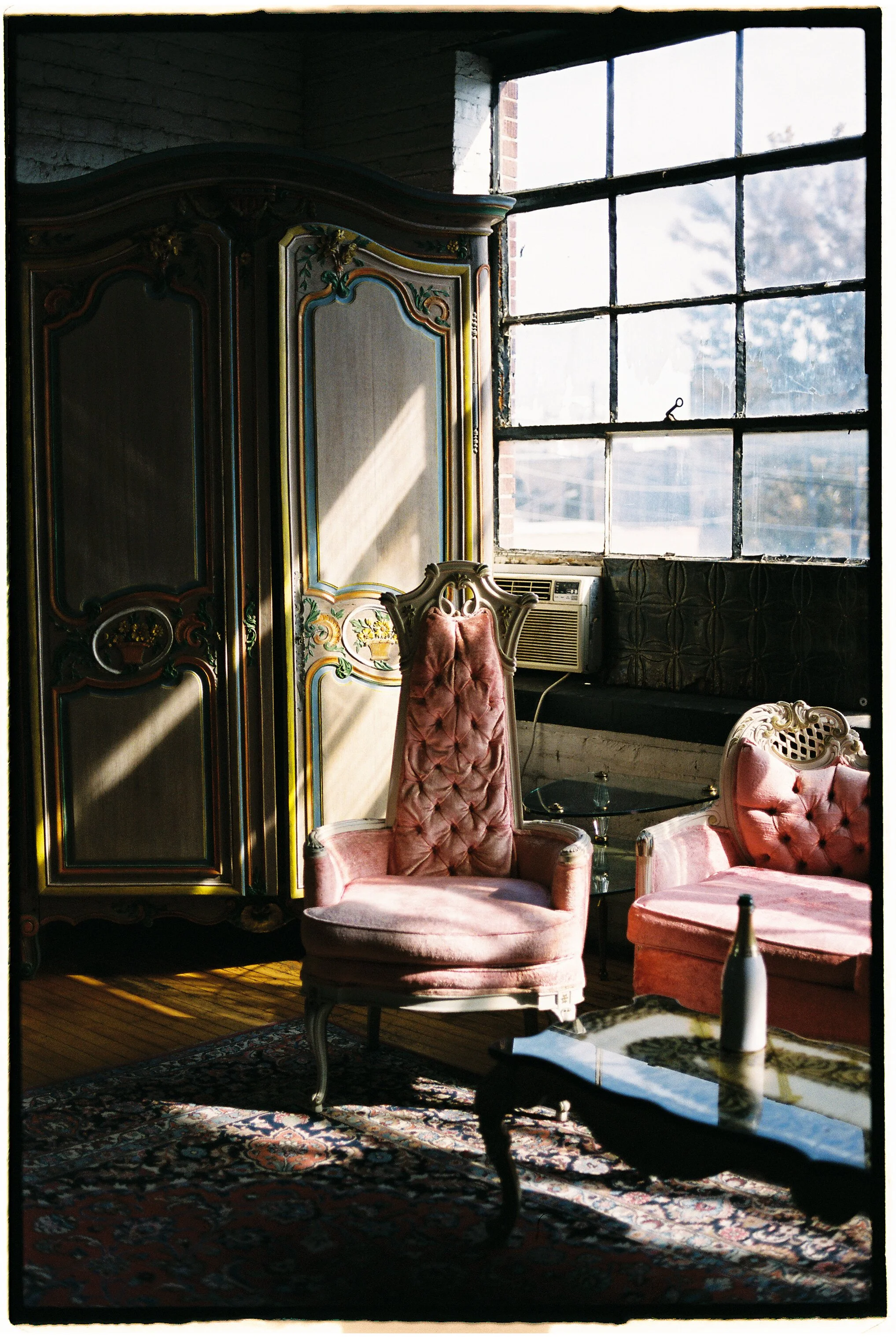 Vintage furniture setup with velvet chairs and antique wardrobe inside Salvage One Chicago