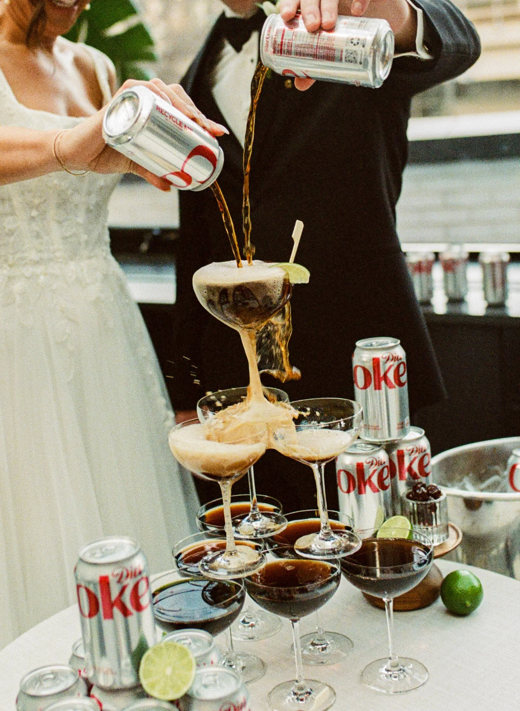  Diet cokes being poured into stacked coupe glasses during a wedding reception cocktail hour   