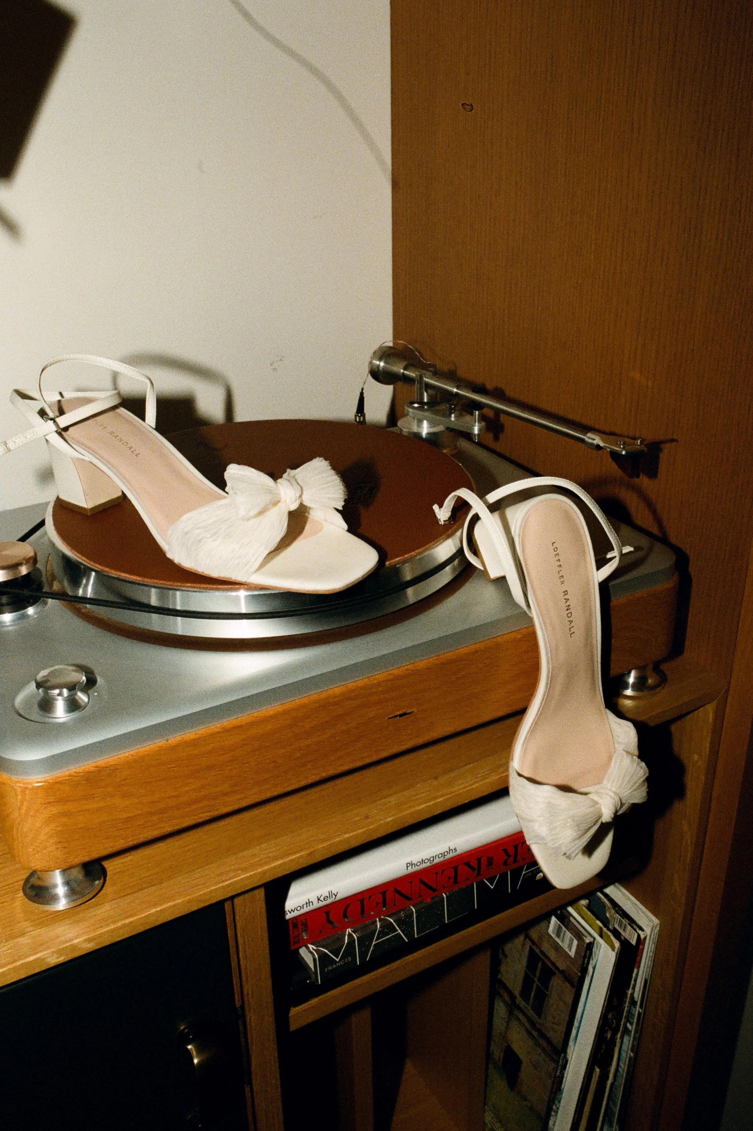 White bridal heels displayed on a vintage record player in a stylish hotel suite
